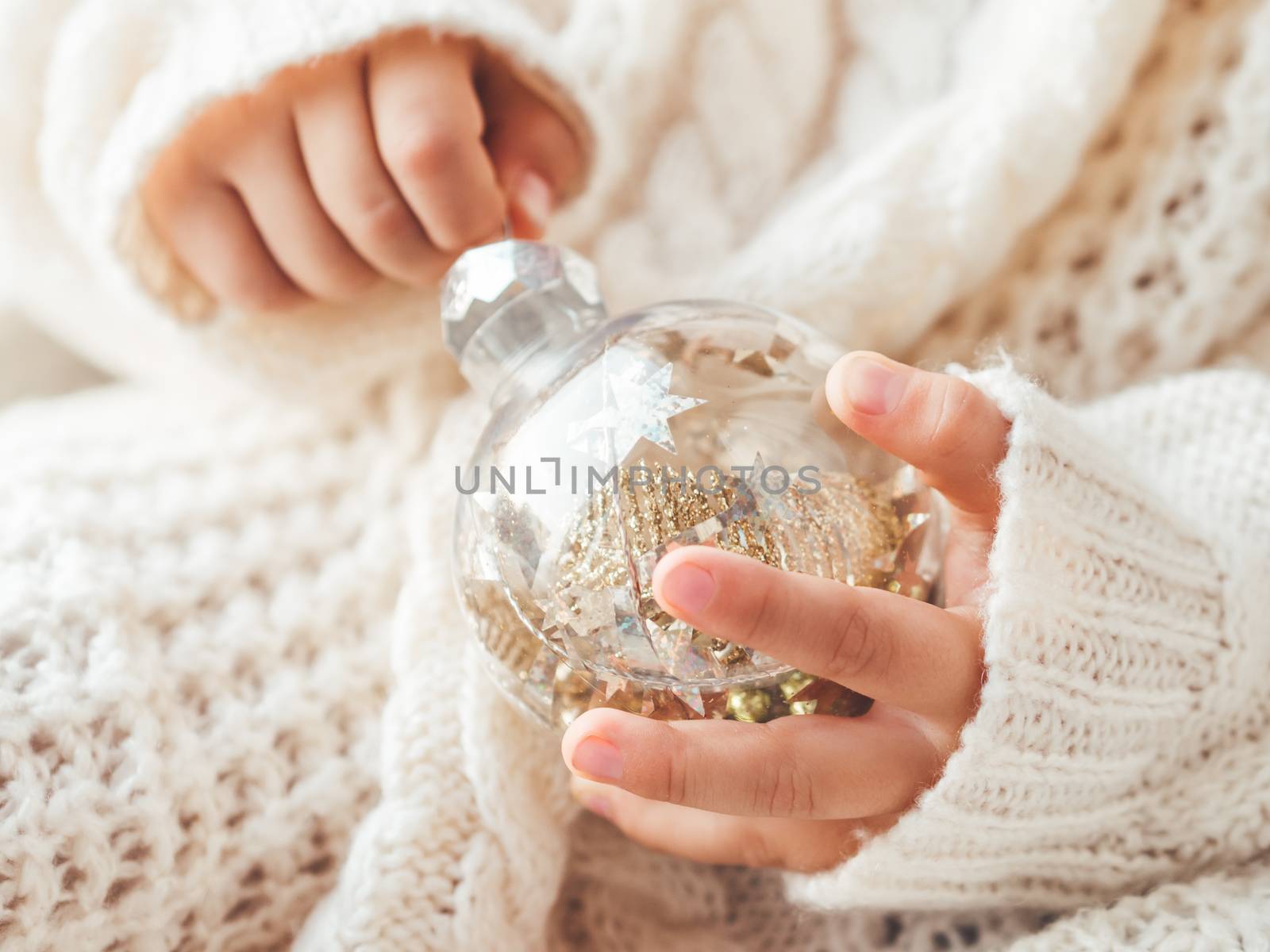 Kid with decorative balls for Christmas tree.Boy in cable-knit o by aksenovko