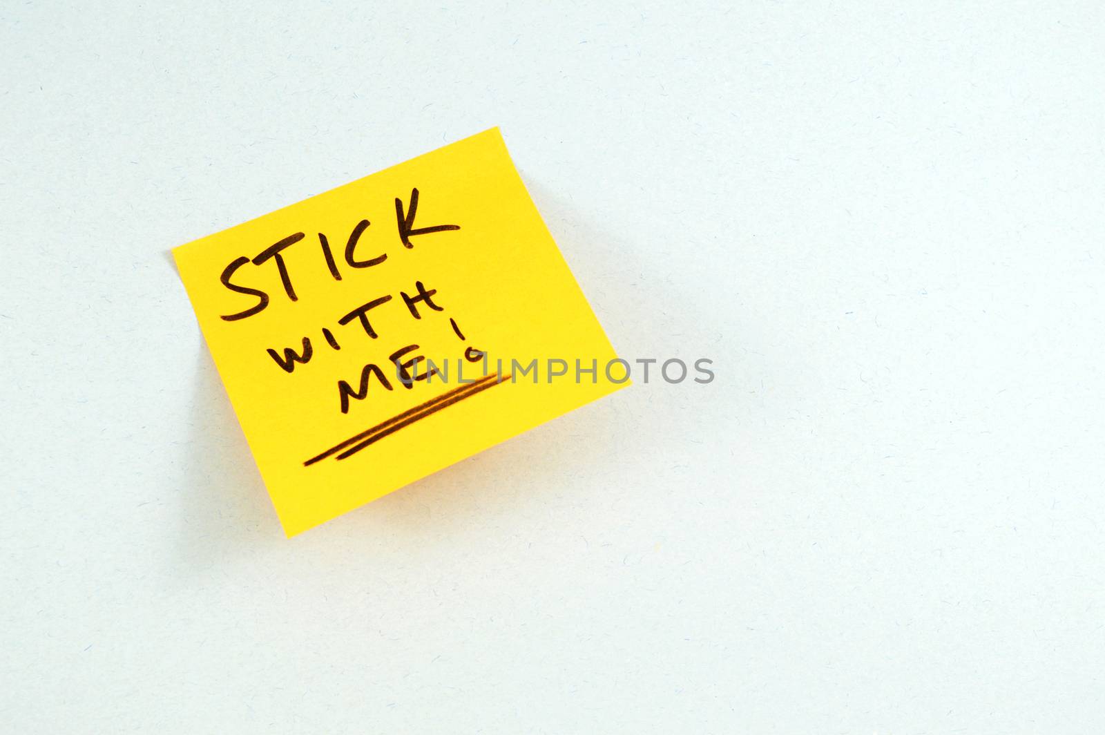 A pun playing with the written words STICK WITH ME on top of a yellow sticky note making the office a little less stressful after reading.