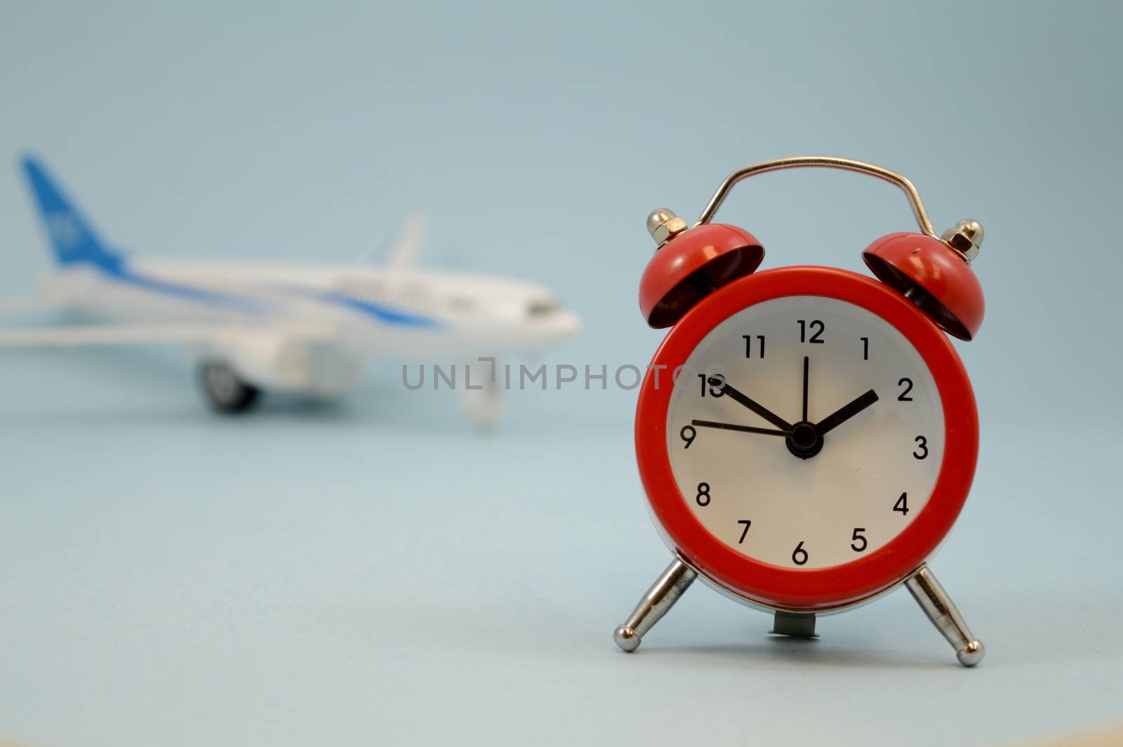 A simple still-life showing an airplane and clock for several travel concepts.