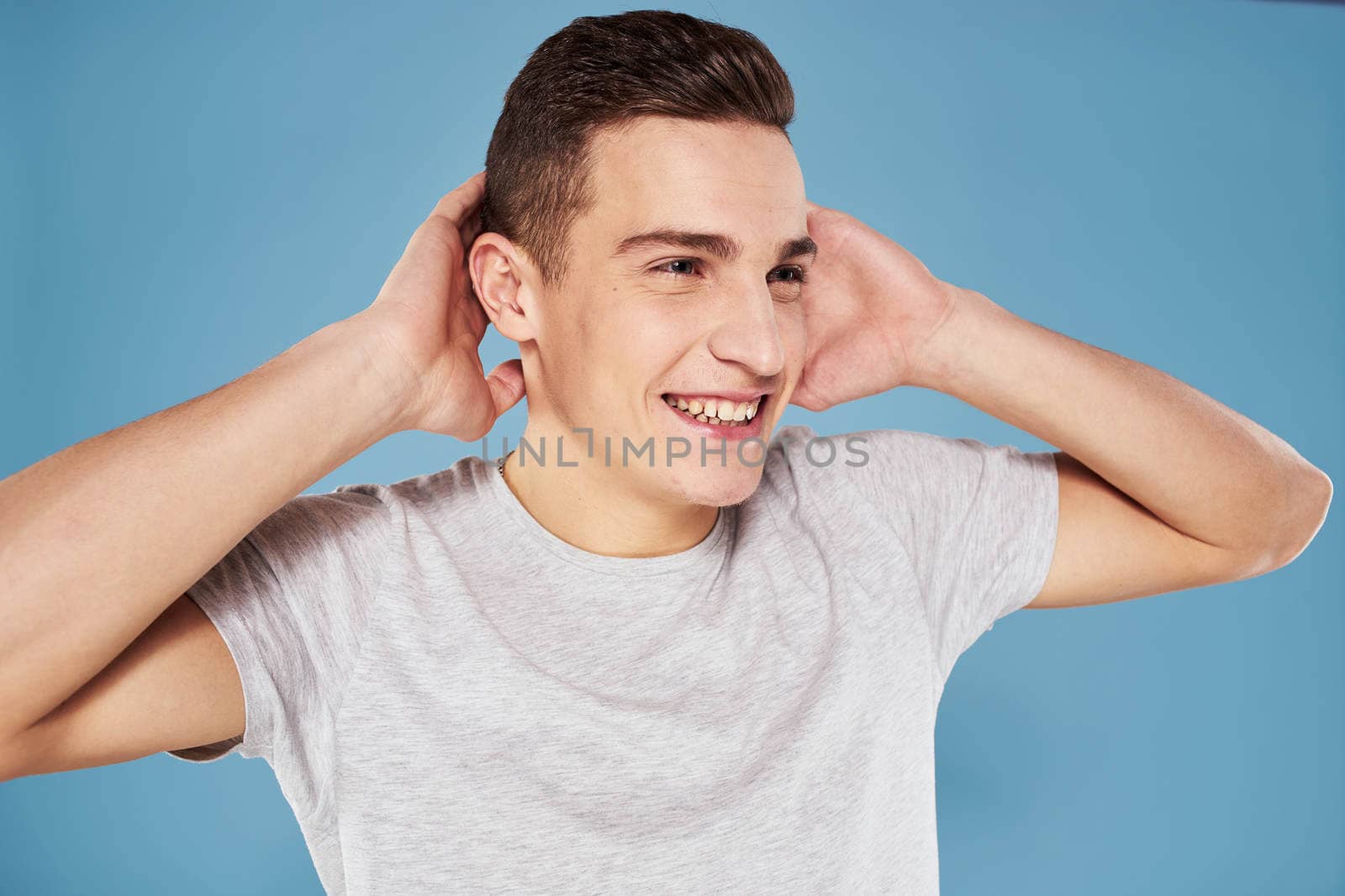 Emotional man in white t-shirt cropped view on blue background lifestyle. High quality photo