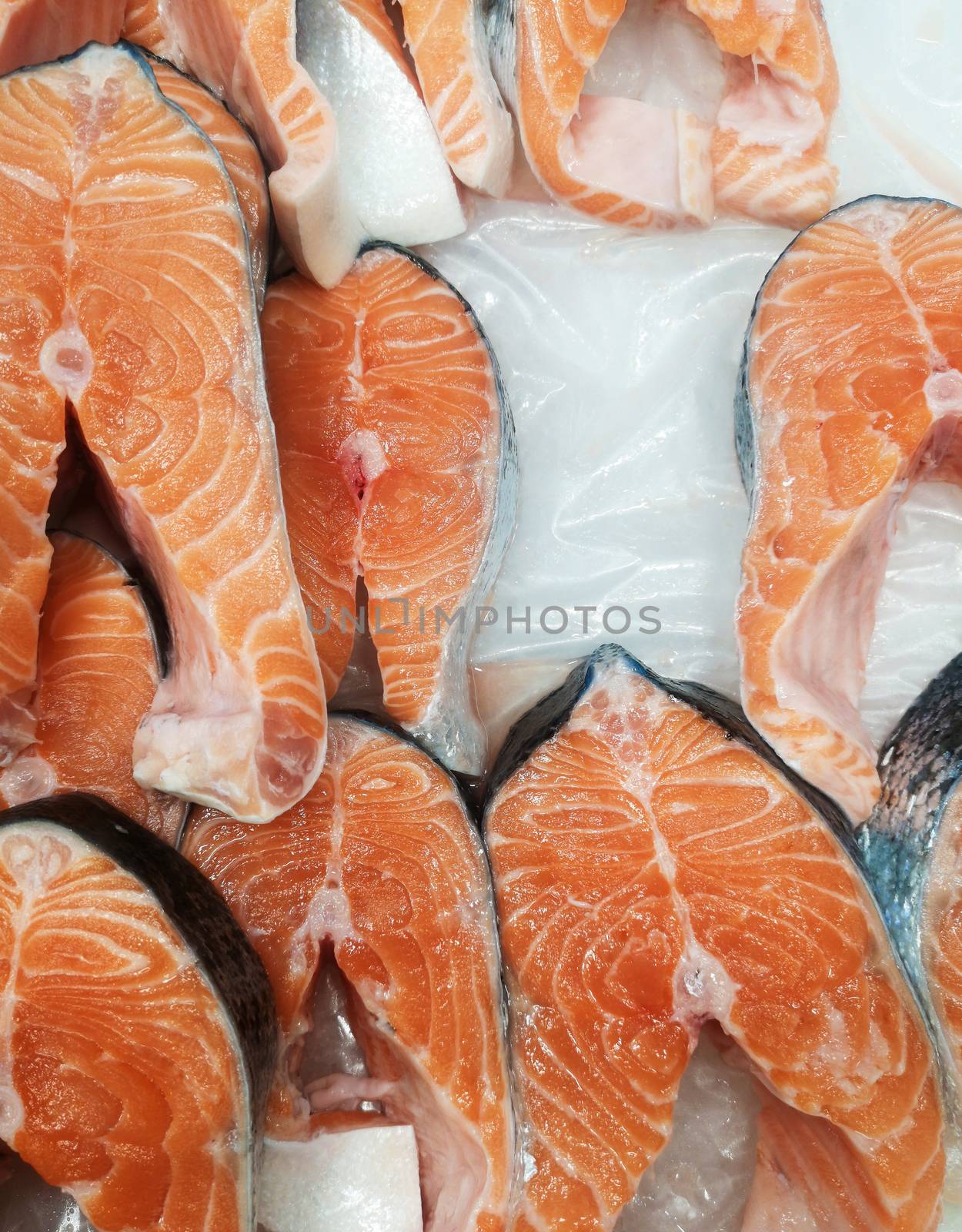 Steaks of fresh salmon red fish on the store counter in ice.