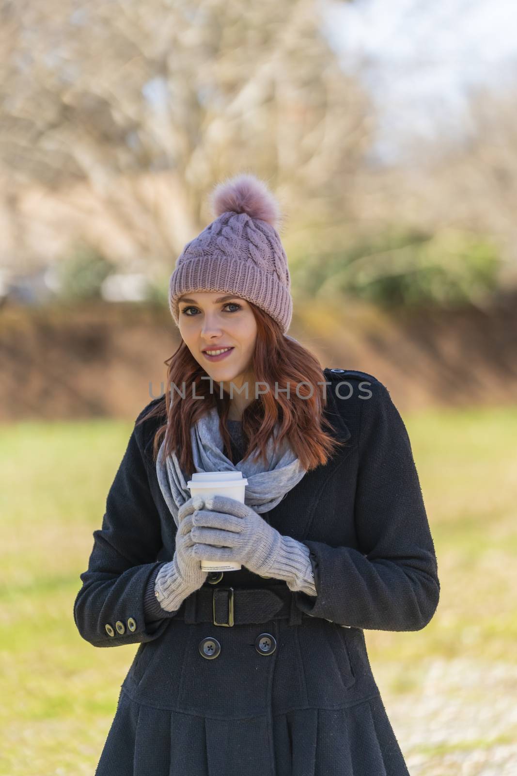 A gorgeous blonde model enjoys a winters day outdoors while drinking her favorite drink