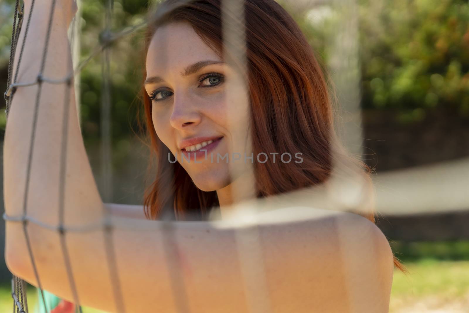 A Gorgeous Redhead Fitness Model Preparing To Play Volleyball by actionsports