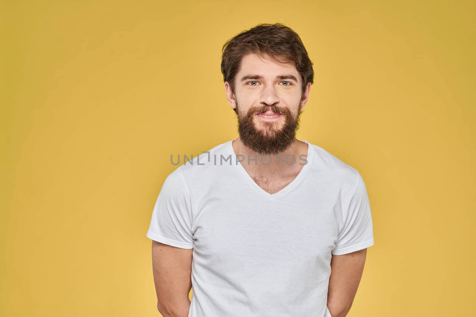 Bearded man on emotions white t-shirt fun lifestyle yellow background. High quality photo