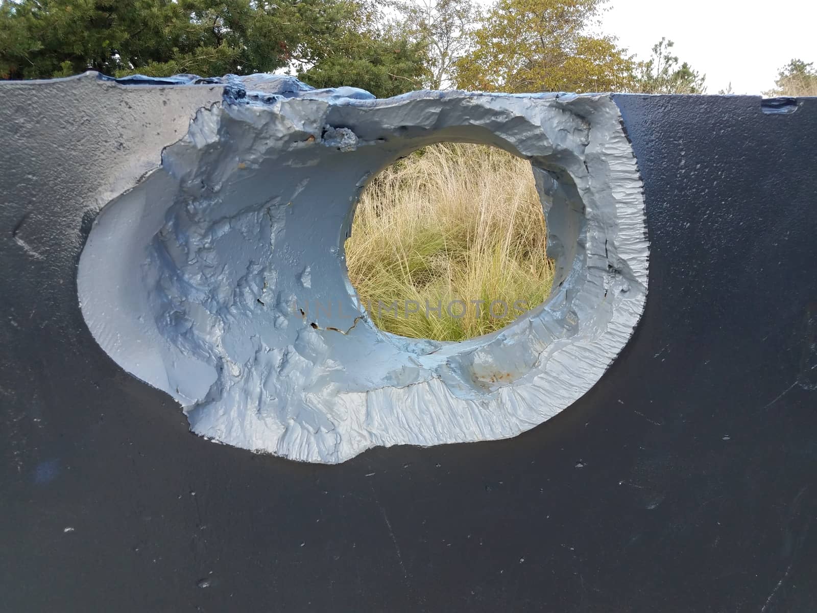 large hole or damage in metal wall outdoor by stockphotofan1