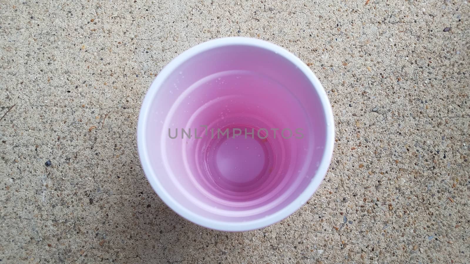 inside white and red plastic cup on grey cement by stockphotofan1