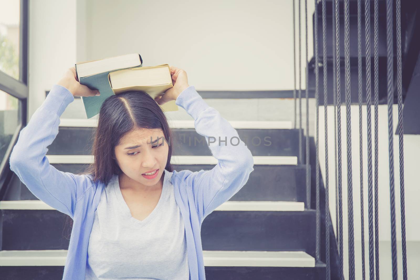 Beautiful of portrait asian young woman holding book, girl tired and bored reading book studying for exams, education and lifestyle concept.