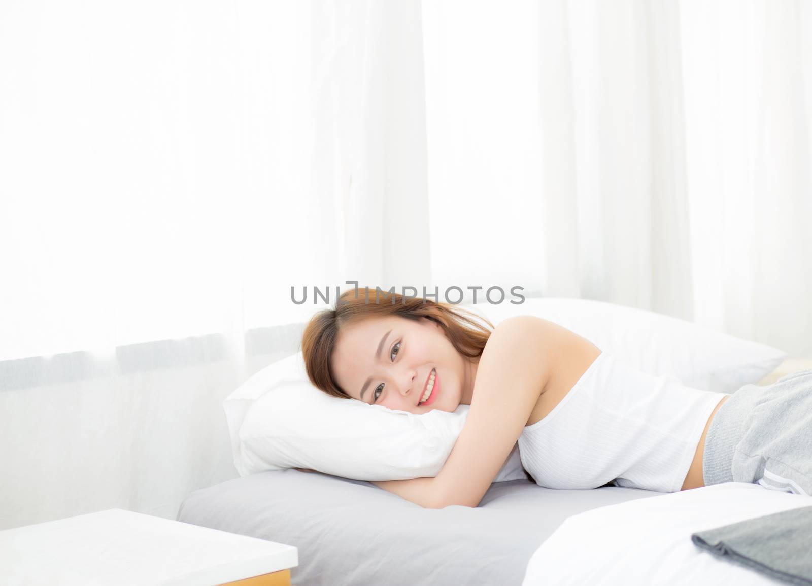 Portrait of beautiful asian young woman sleep lying in bed with head on pillow comfortable and happy with leisure, girl with relax  for health and lifestyle concept.