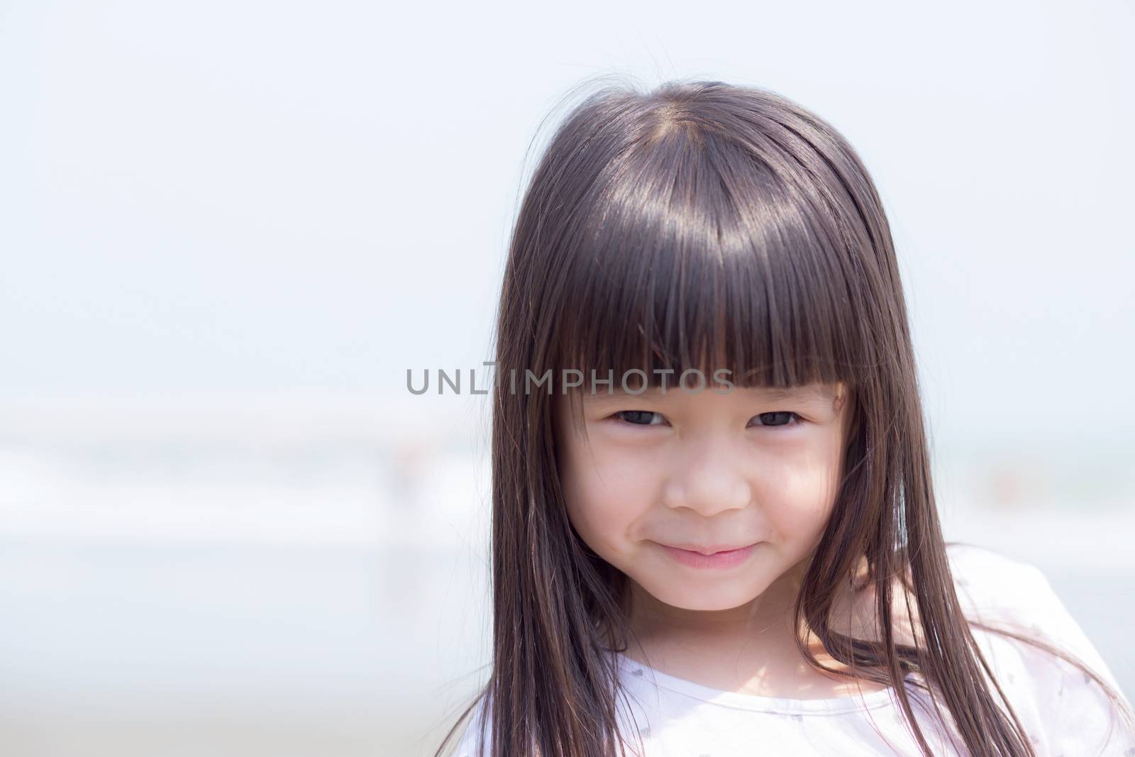 Beautiful portrait little girl asian of a smiling standing at beach, kid leisure and joyful in outdoor.