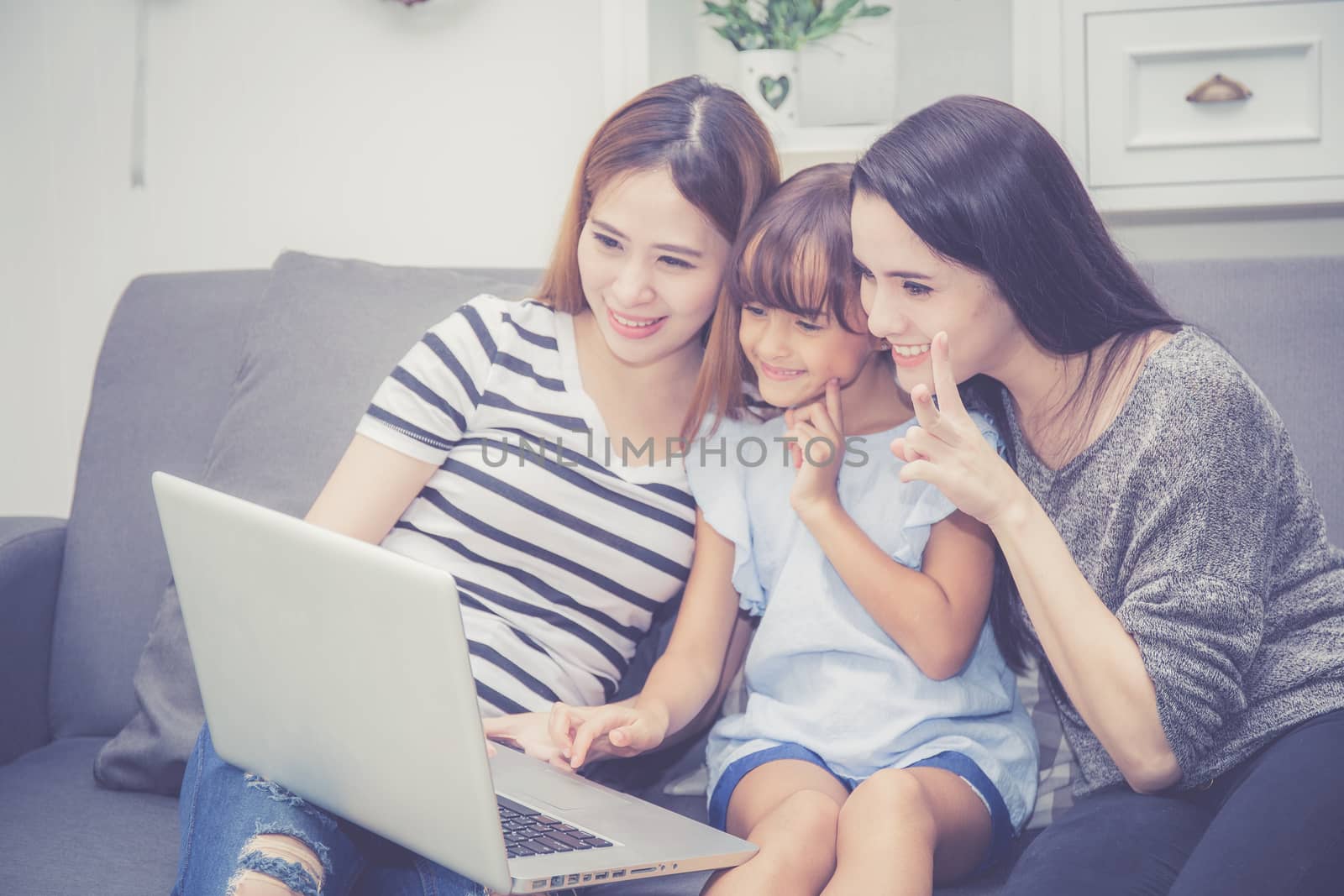 Mother, Aunt and kid having time together lerning with using laptop computer at home with relax and happy on couch, education and lifestyle concept.