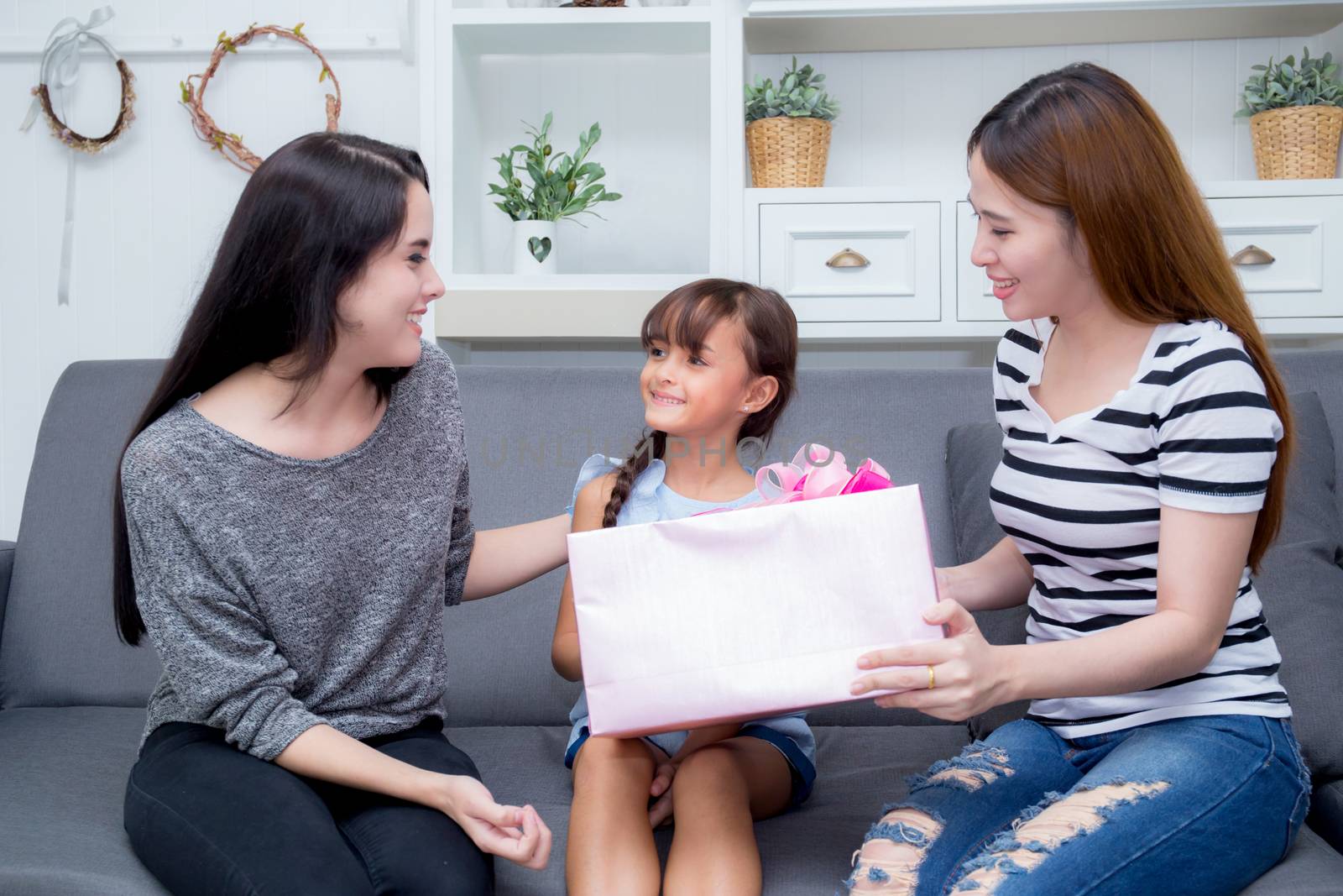 happy of mother and daughter woman asian and aunt with gift with pink ribbon and daughter kissing mother, Happy family concept. Happy mother's day.