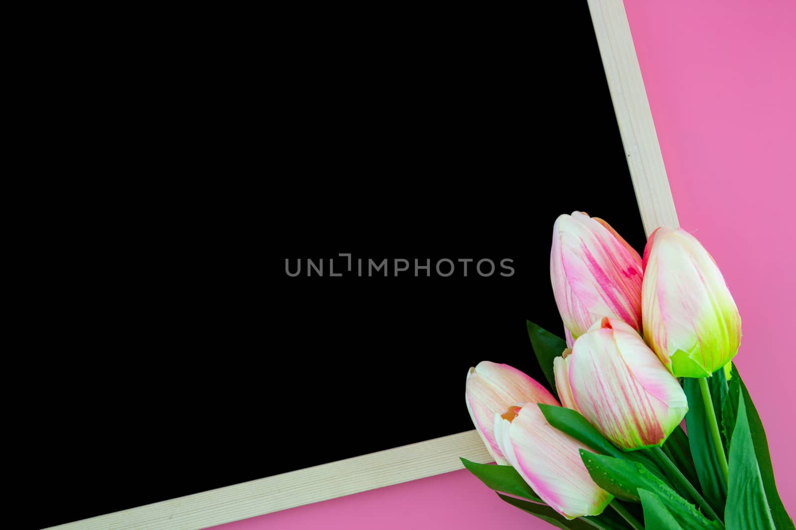 Beautiful of yellow tulip flower and chalkboard, blackboard with flat lay on the pink background, top view, copy space, mother day and holiday concept.