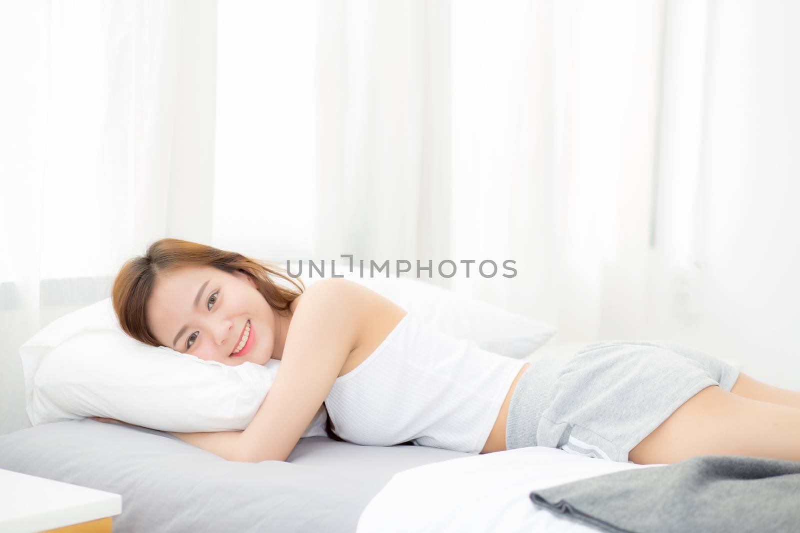 Portrait of beautiful asian young woman sleep lying in bed with head on pillow comfortable and happy with leisure, girl with relax  for health and lifestyle concept.
