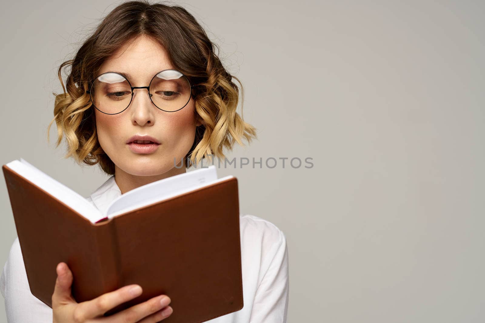 Business woman with notepad and glasses on a light background hairstyle success emotions. High quality photo