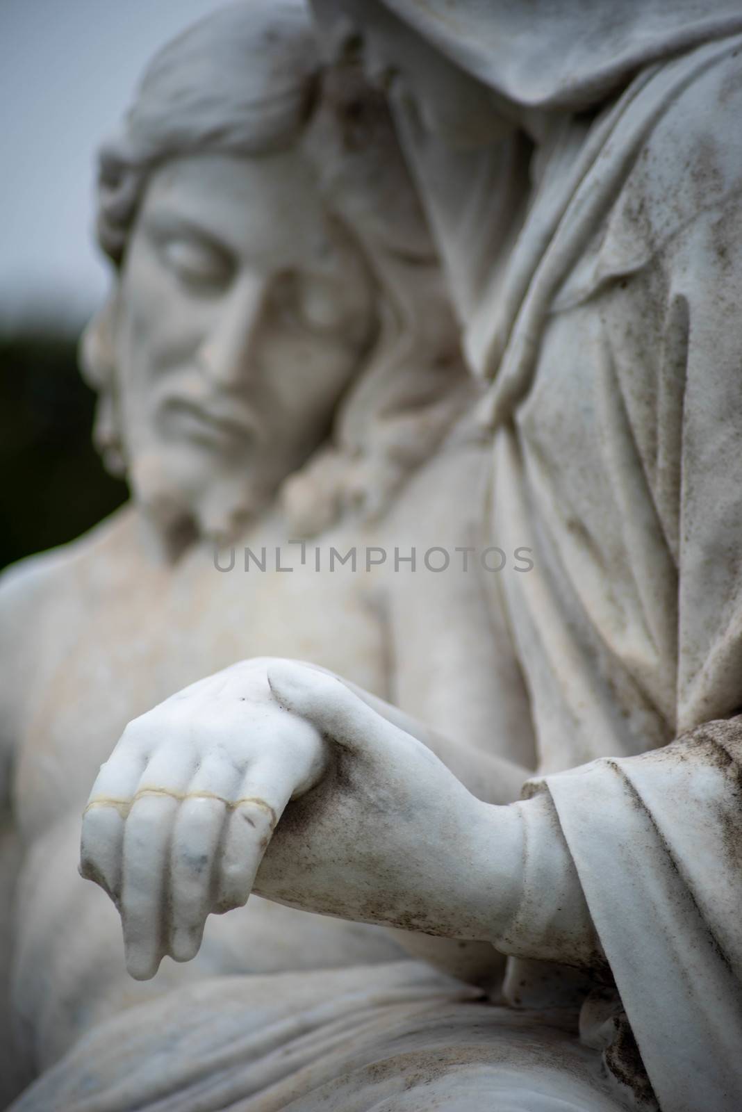 Mary holds Jesus's broken hand in a Victorian cemetery pieta, beautiful tenderness in natural light with copy space
