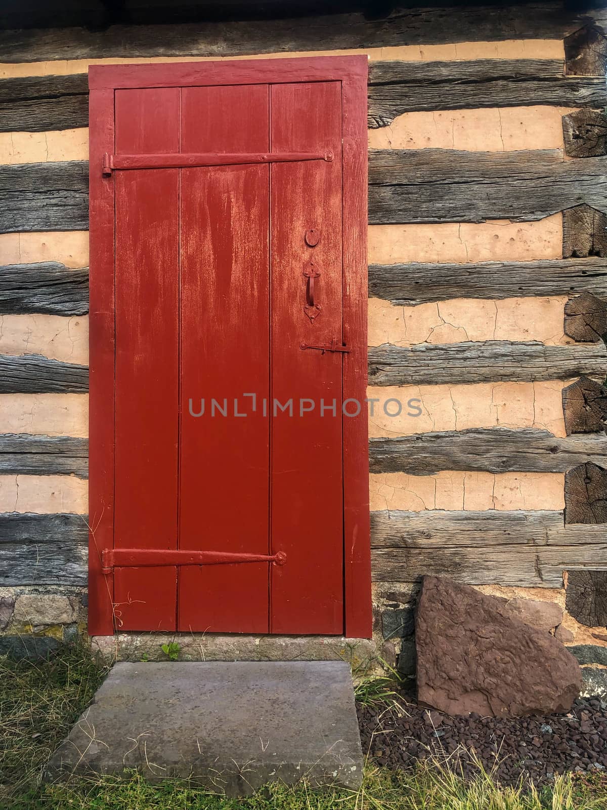 Red door in Pennsylvania colonial log cabin by marysalen