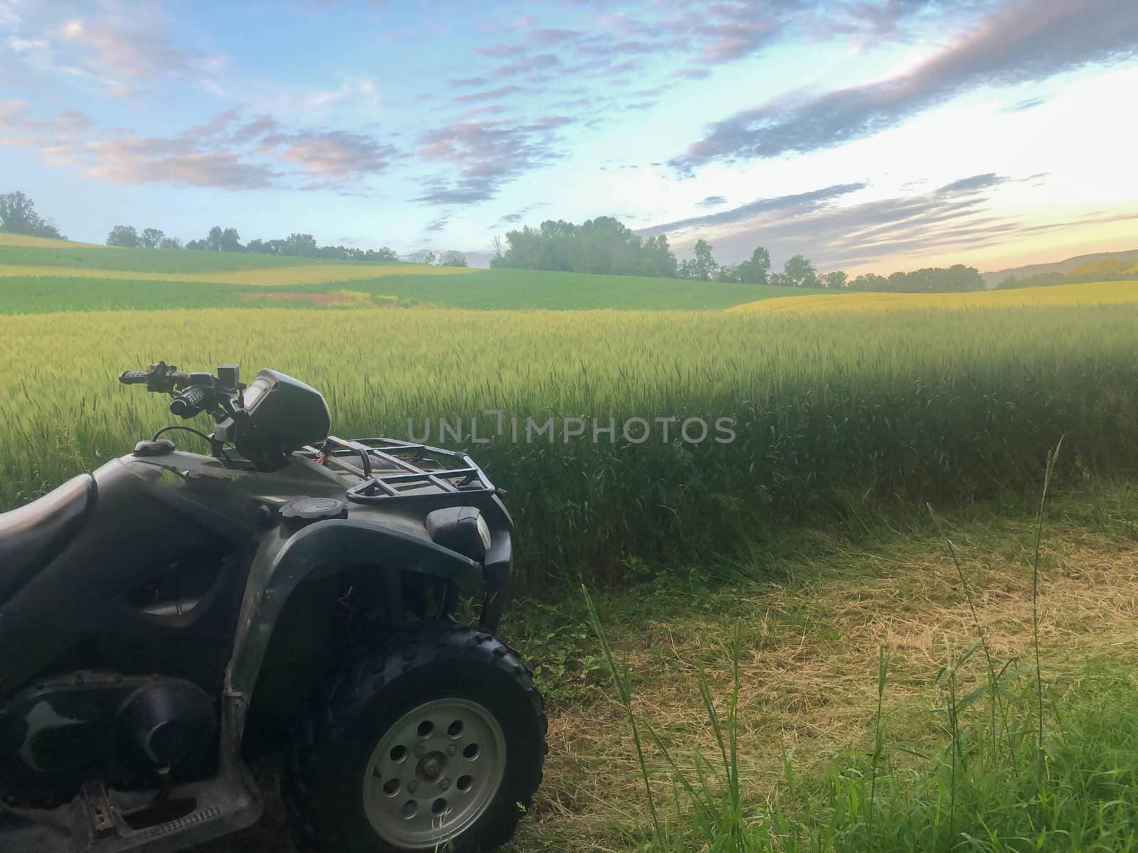 Golden hour rural landscape with off road vehicle in foreground, serene colors and textures to the horizon with a pink sky and copy space.