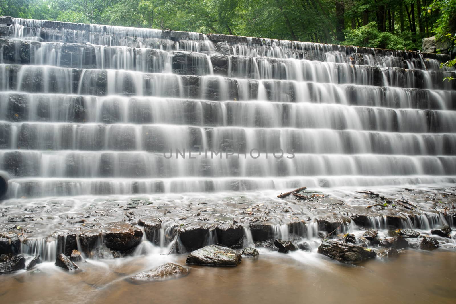 Long exposure of cascading water down tiered rock face in a fore by marysalen