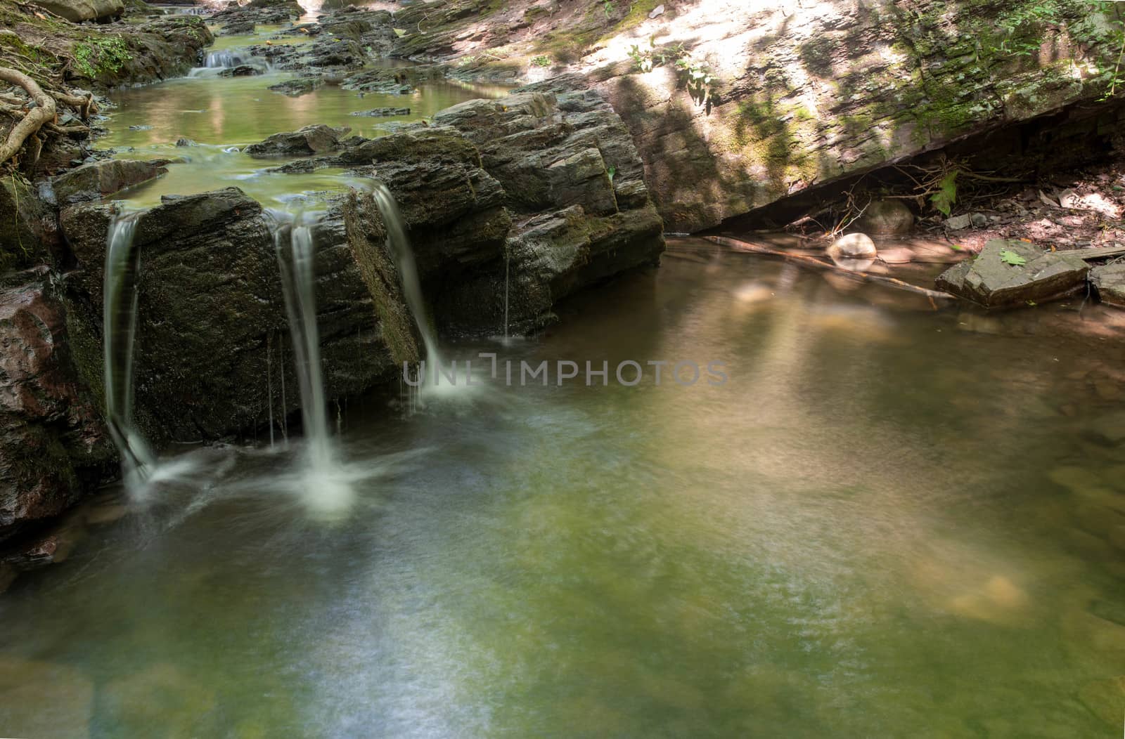 Long exposure of a woodland waterfall and reflecting pool. by marysalen