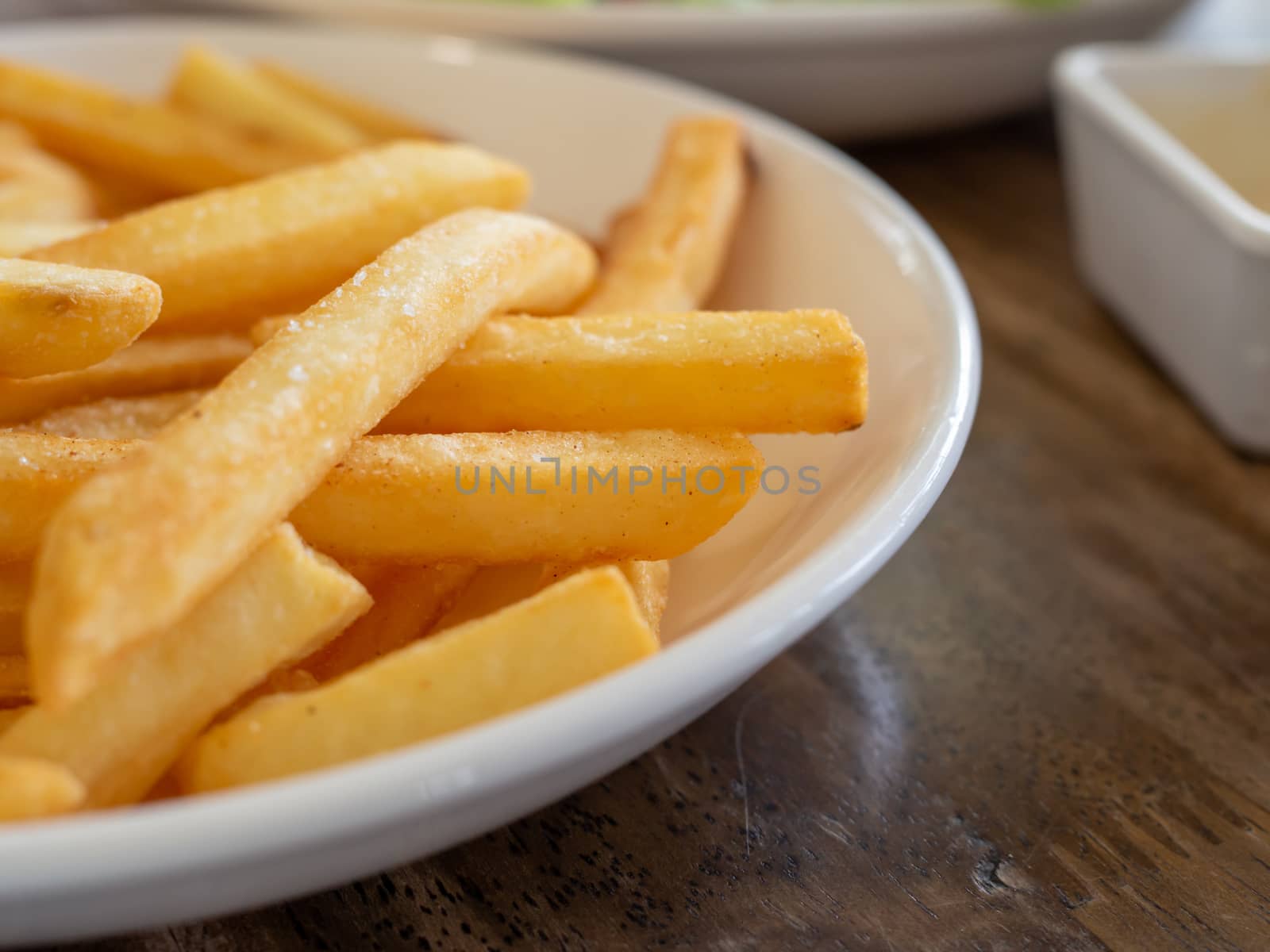 French fries are on a white plate. With copy space