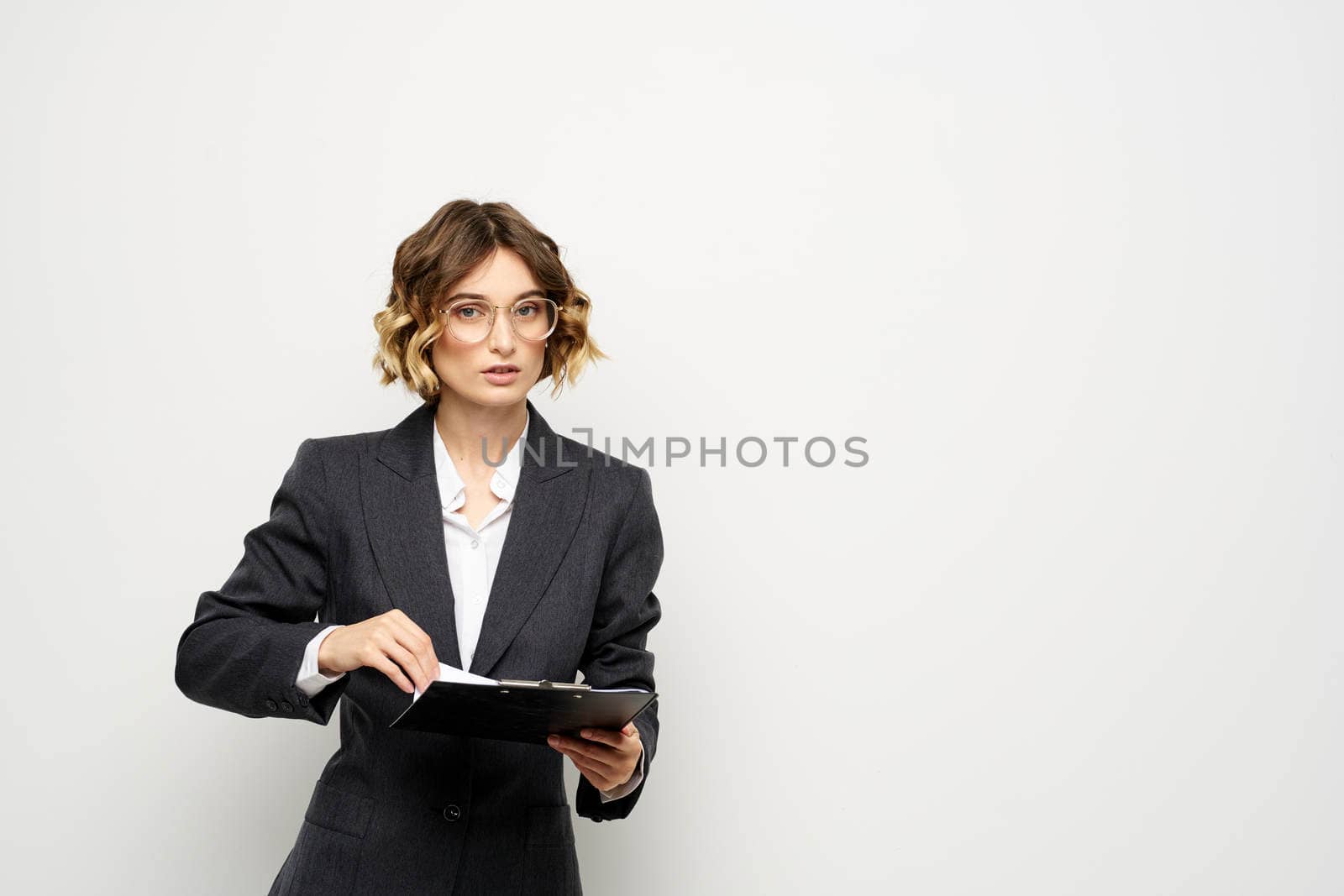 business woman in a suit with documents in hands light background curly hair hairstyle. High quality photo