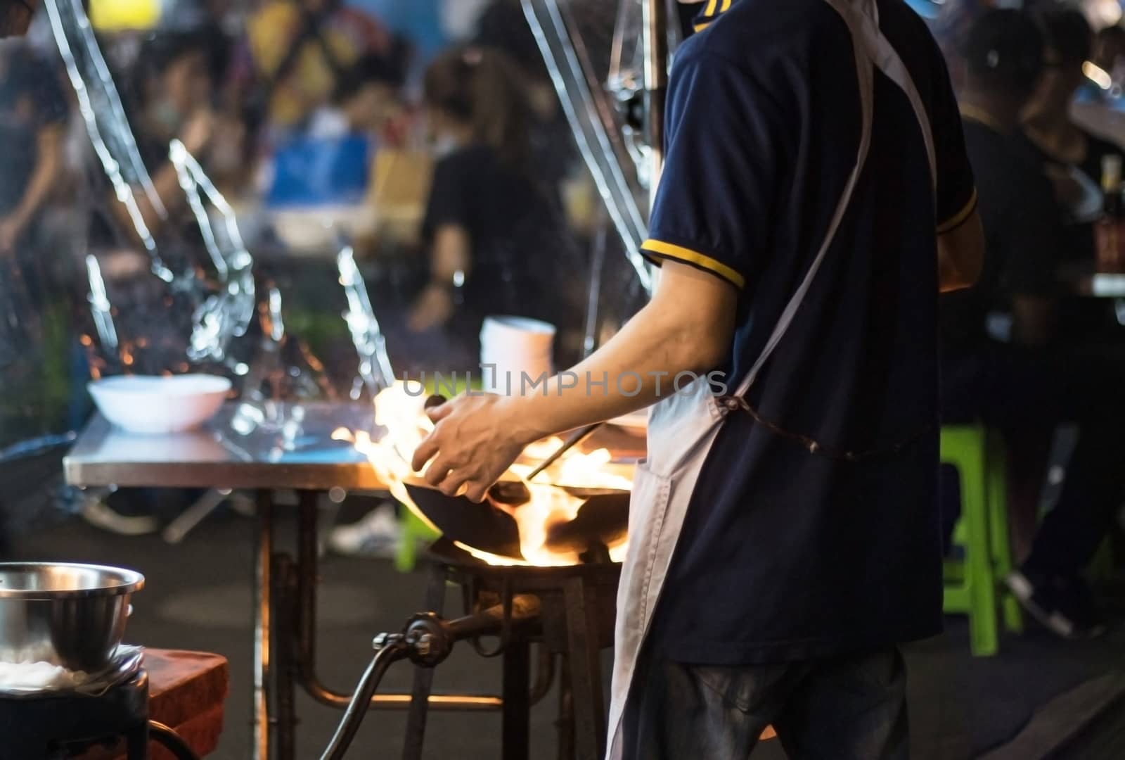 Street food in Bangkok Bangkok Thailand - Oct 24, 2020 :- Chef cooking with fire with frying pan on gas hob at yoawarat Bangkok Thailand.