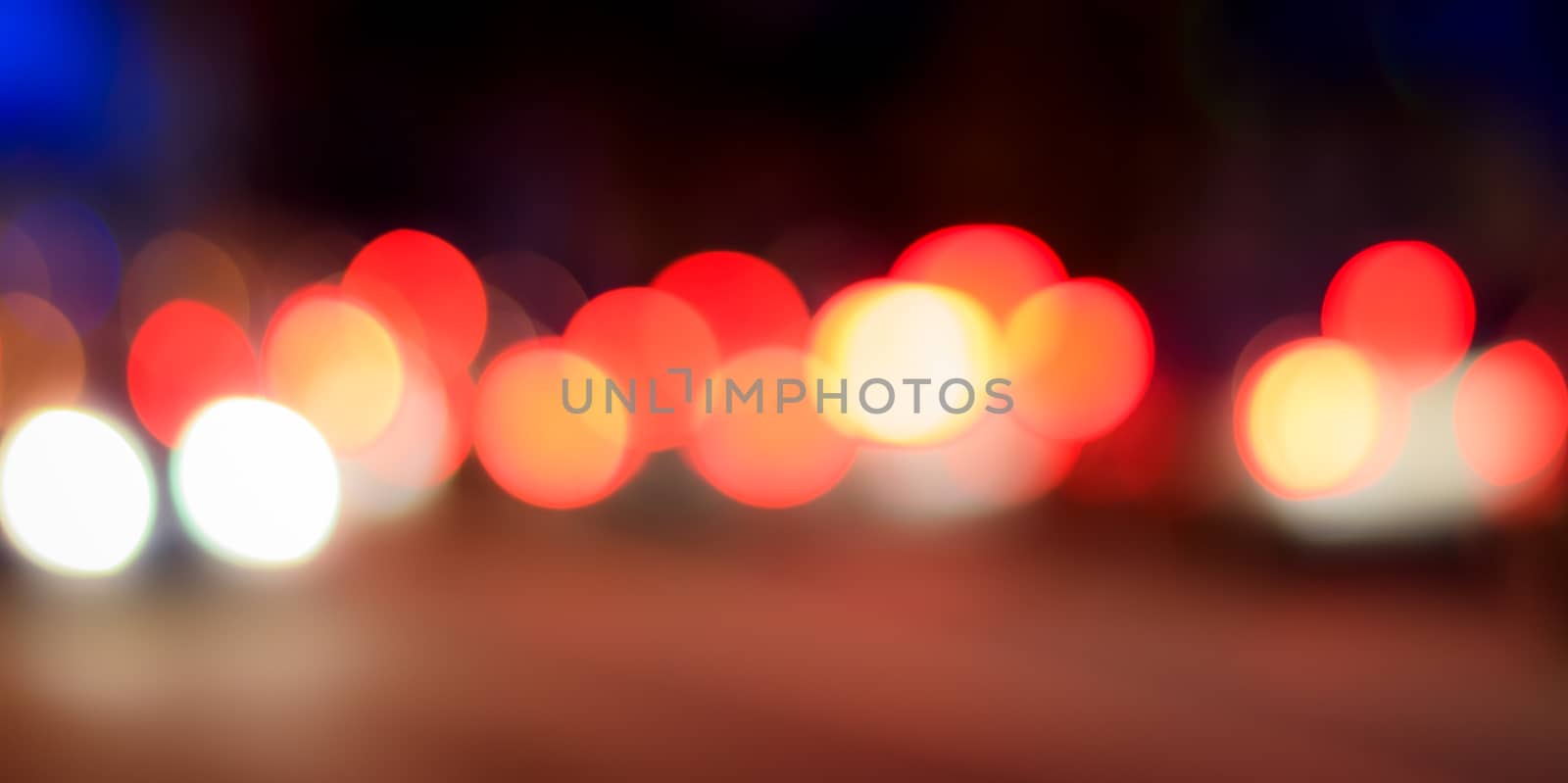 Blurred lights of headlights of cars and lanterns in the night city. Abstract bright bokeh.