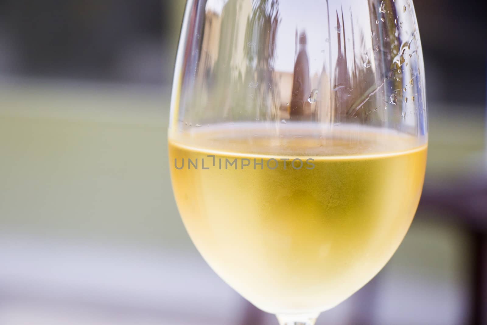 White wine in wineglass close-up background, yellow color