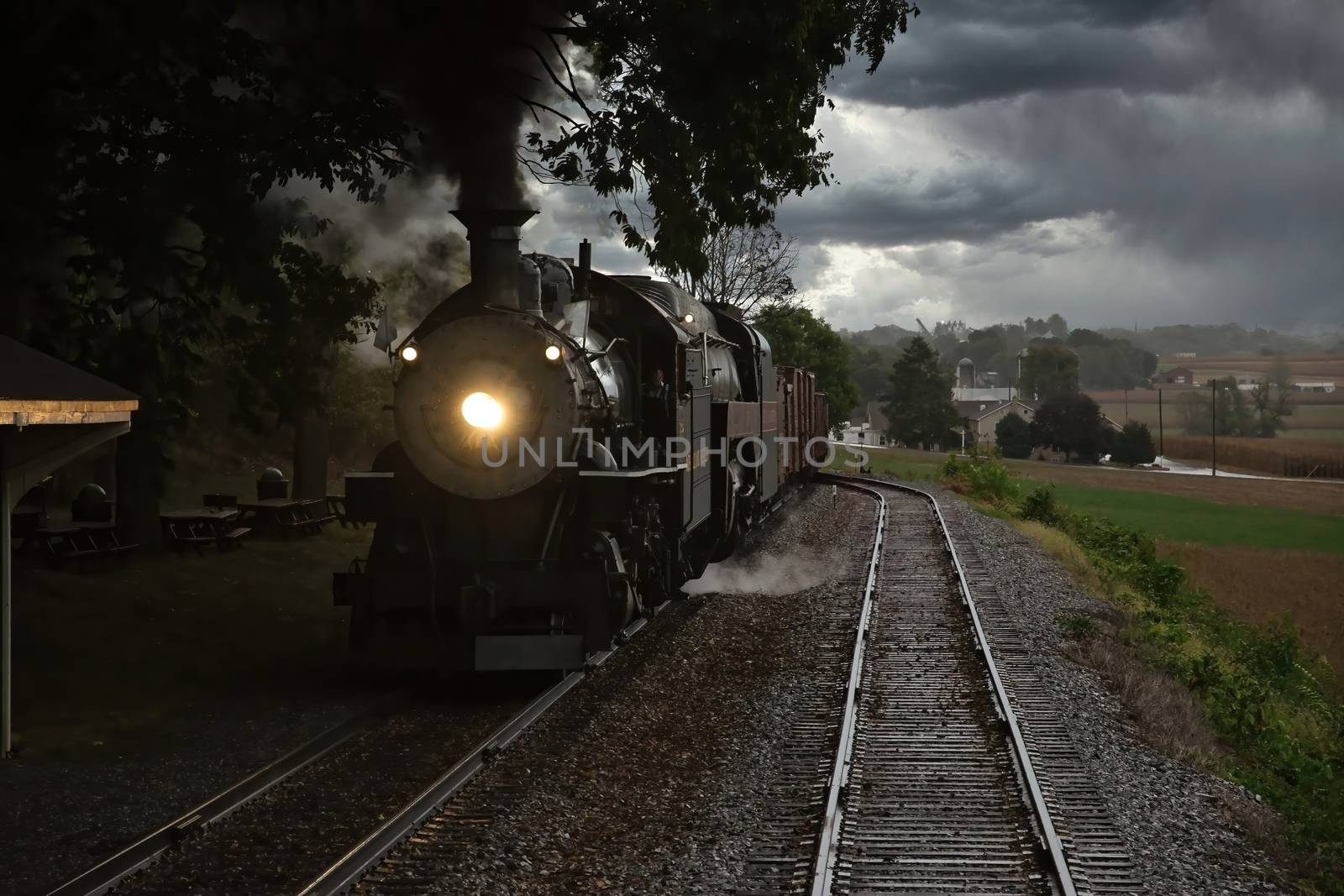 Close up of an Antique Steam Freight Train Puffing Smoke and Steam While going Thru Amish Countryside