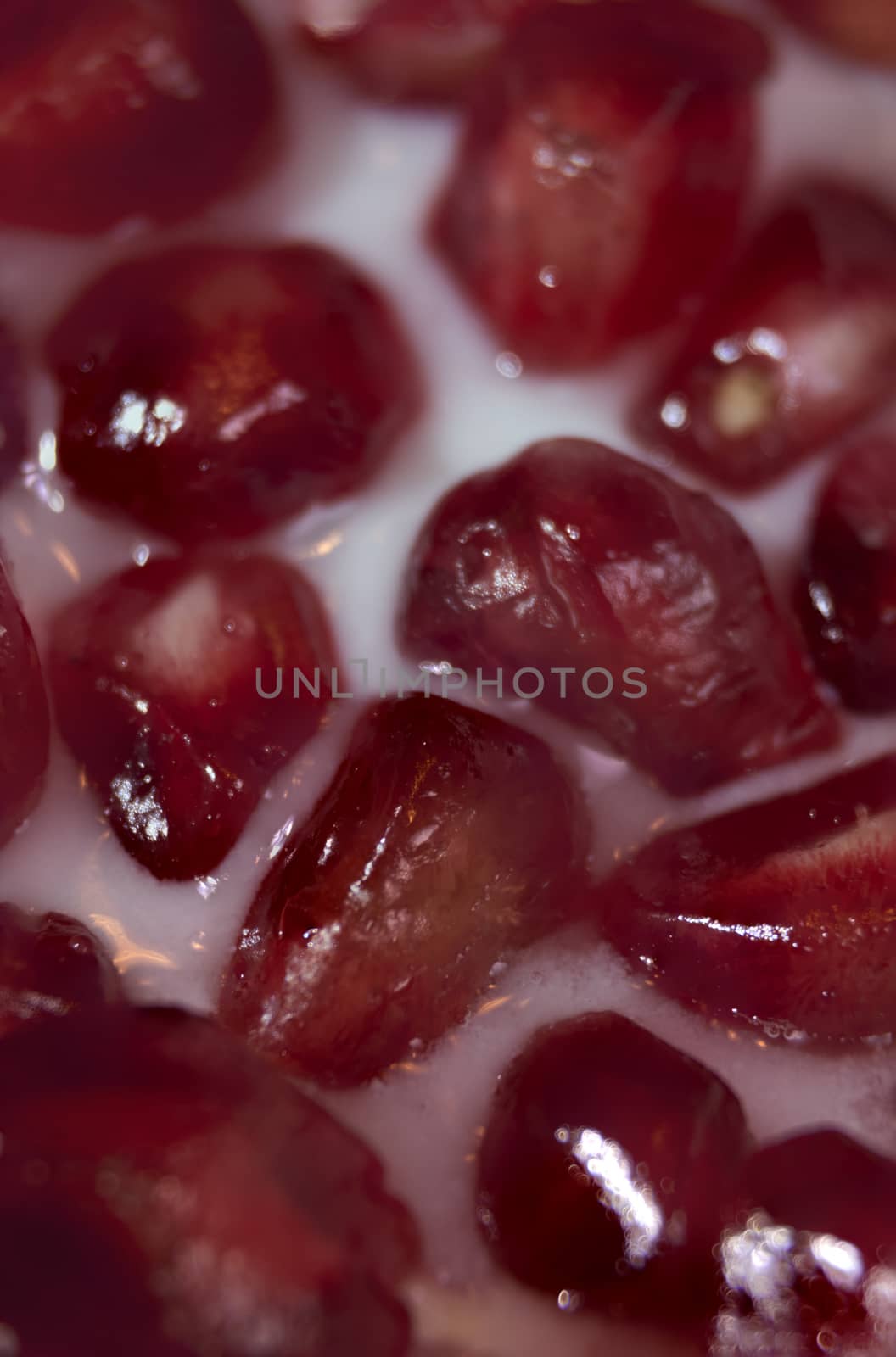 Pomegranate seeds close-up with yogurt, macro photography
