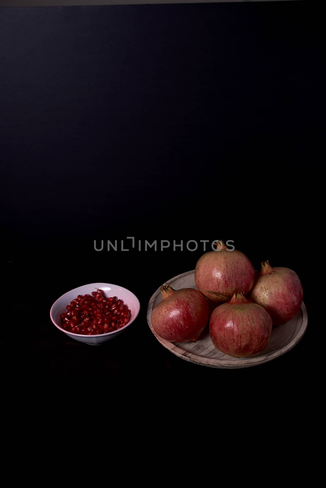 Pomegranate close-up with seeds in bowl close-up, Black background, Black background, macro photography