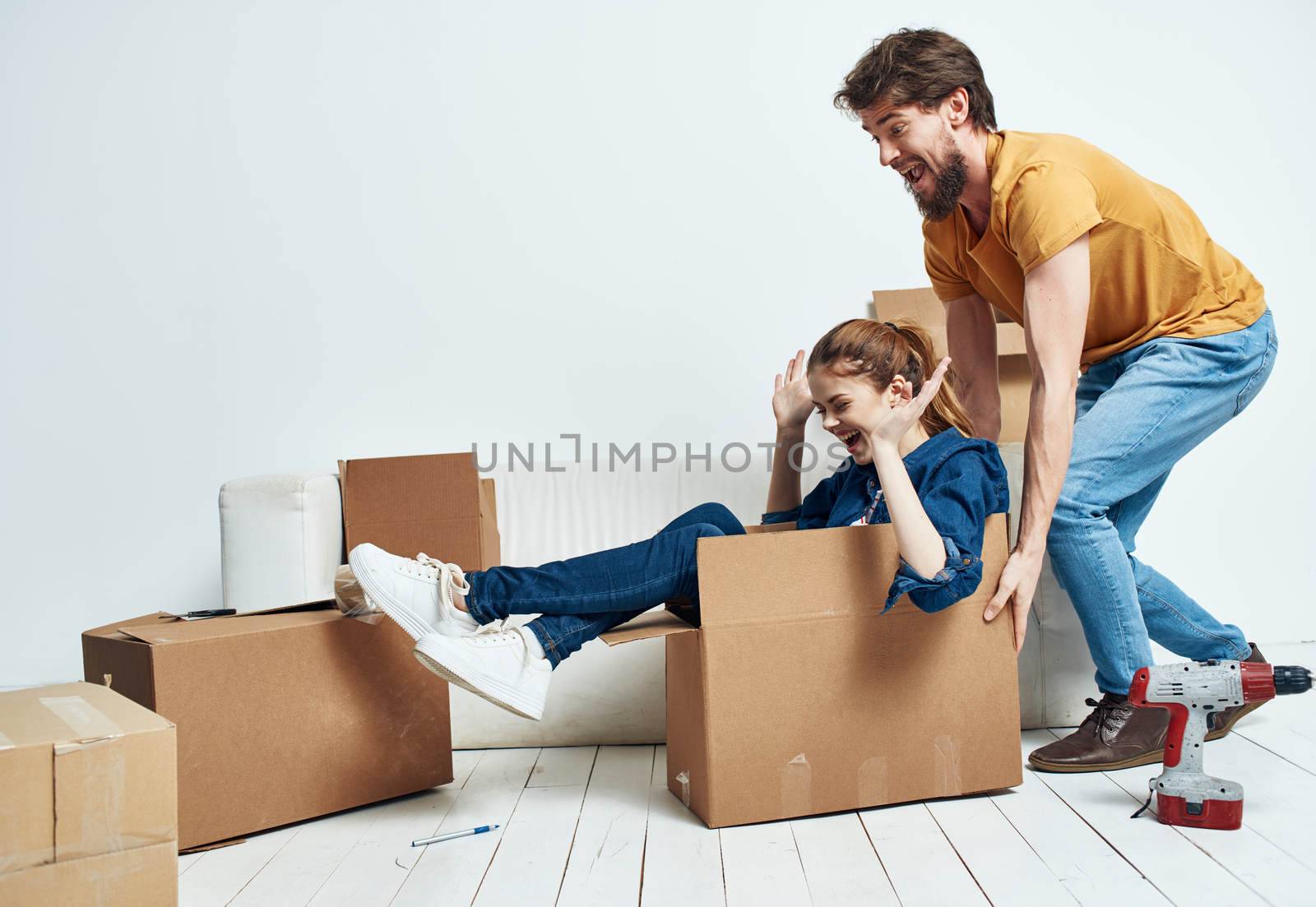 man and woman on white sofa interior cardboard boxes lifestyle. High quality photo