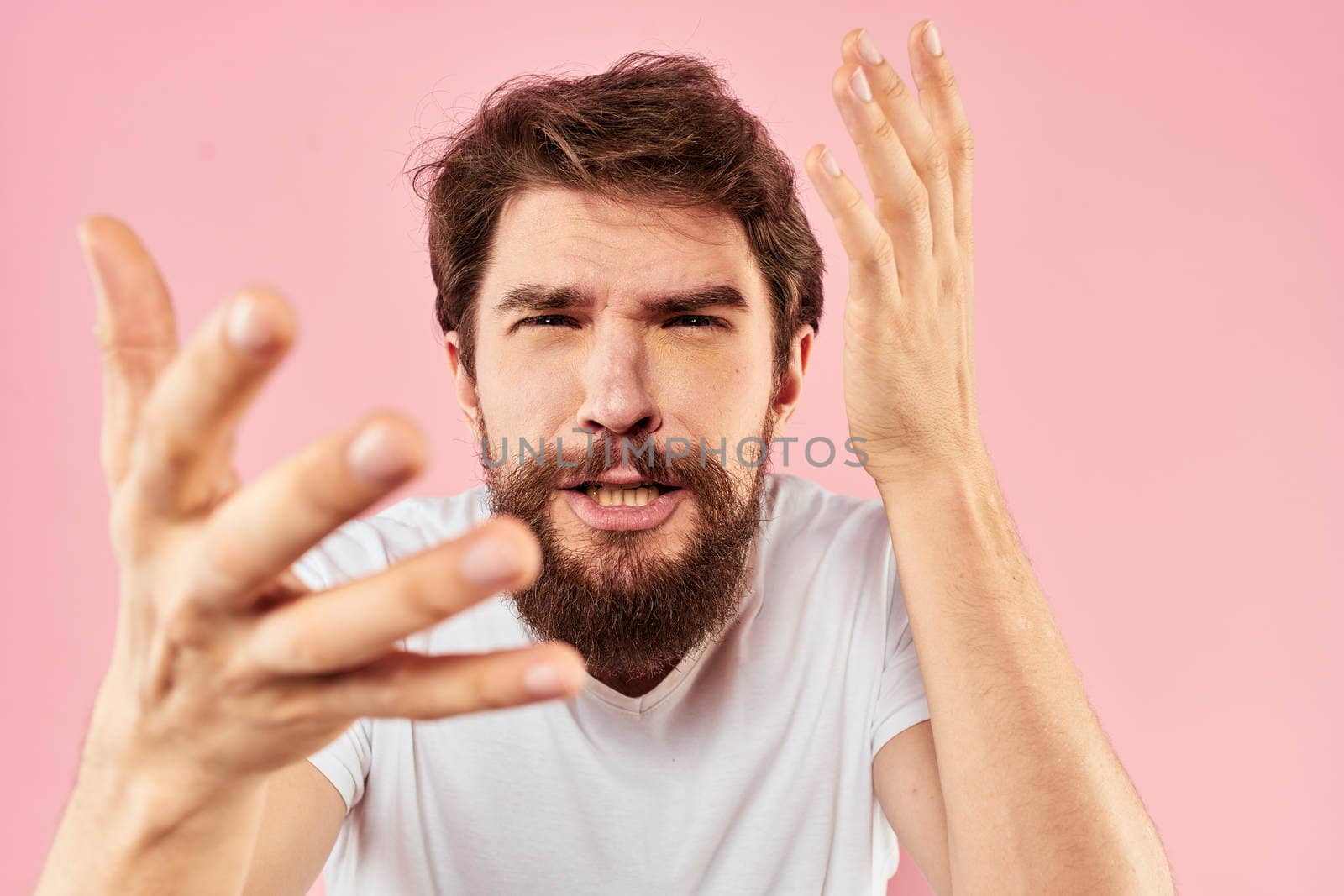 Bearded man white t-shirt cropped view lifestyle studio pink background. High quality photo