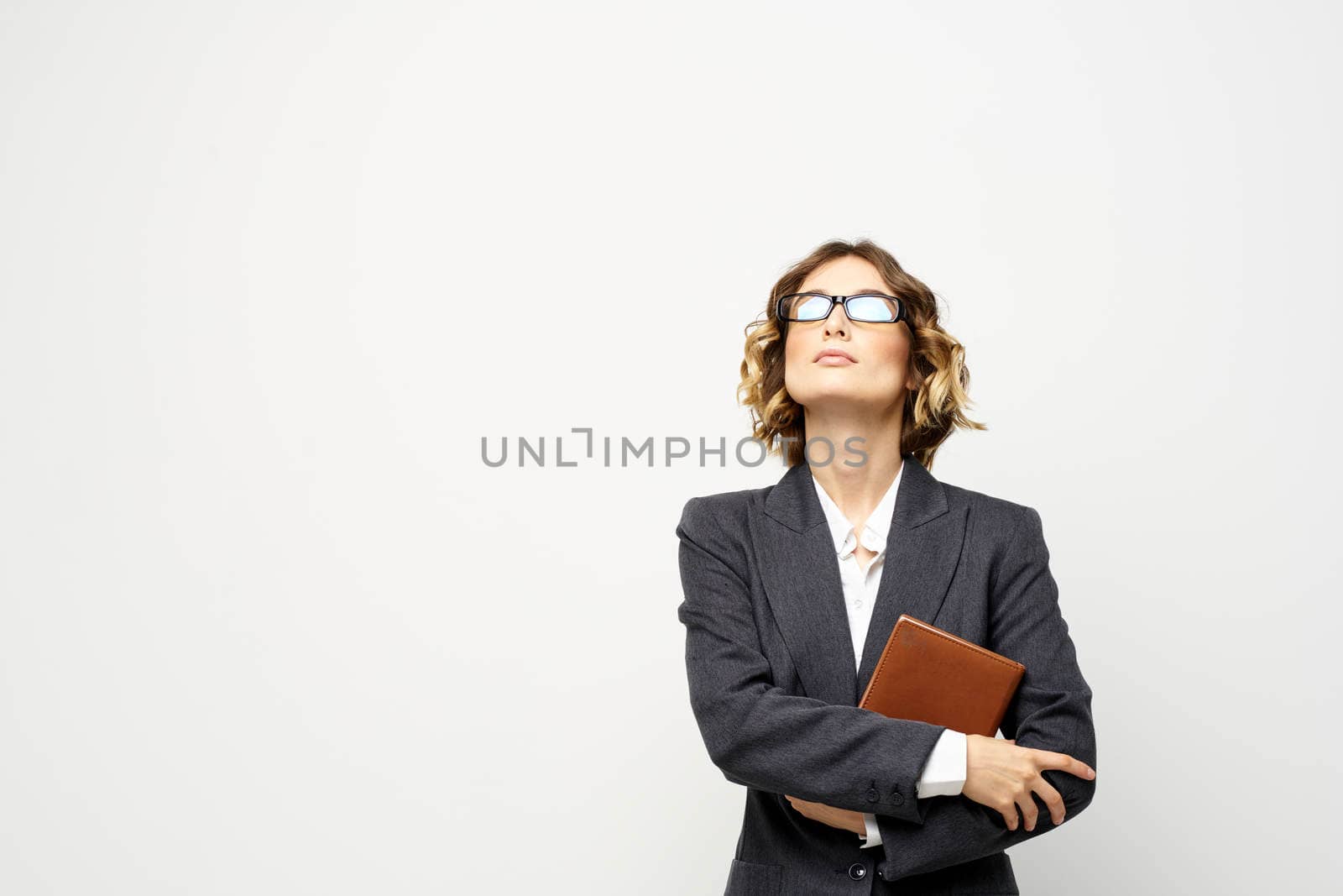 Business woman with notepad and glasses work light background cropped view of suit model. High quality photo