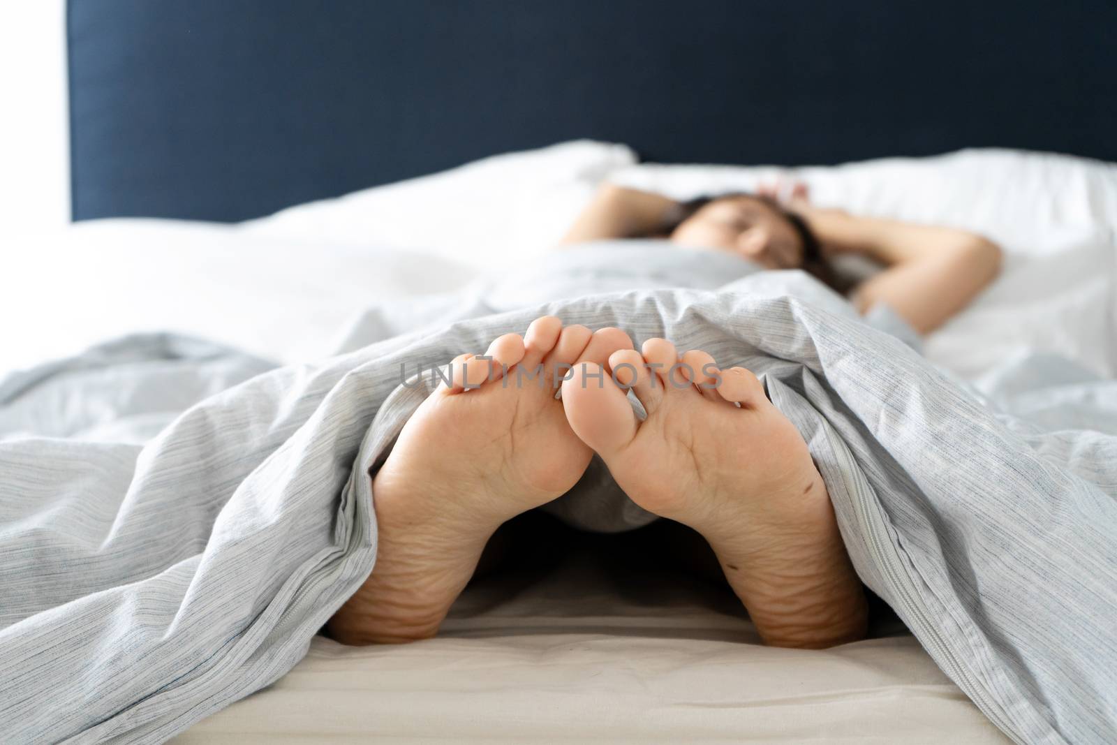 Feet of a sleeping girl in bed in the morning. Spy photo