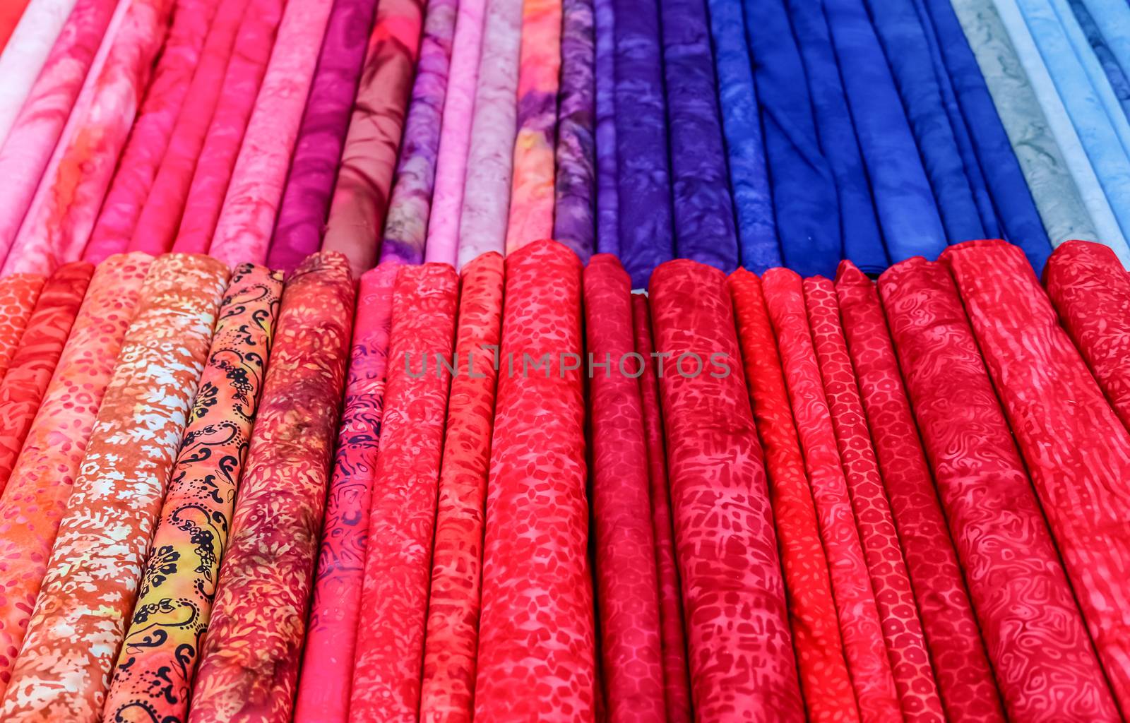 Detailed close up view on samples of cloth and fabrics in different colors found at a fabrics market.