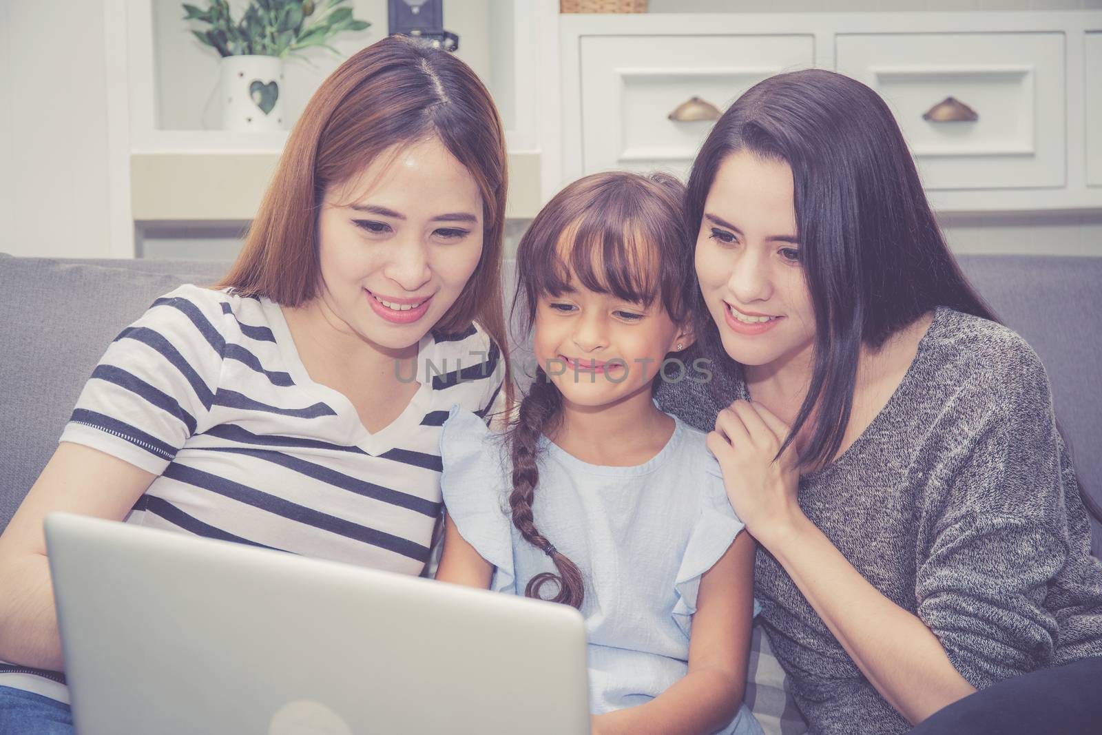 Mother, Aunt and kid having time together lerning with using laptop computer at home with relax and happy on couch, education and lifestyle concept.