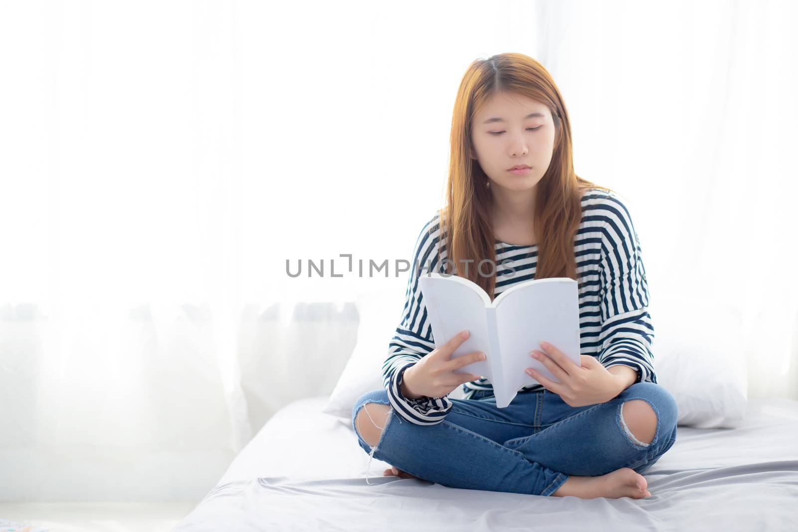 Beautiful of portrait young asian woman relax sitting reading book on bedroom at home, girl study literature, education and llifestyle concept.