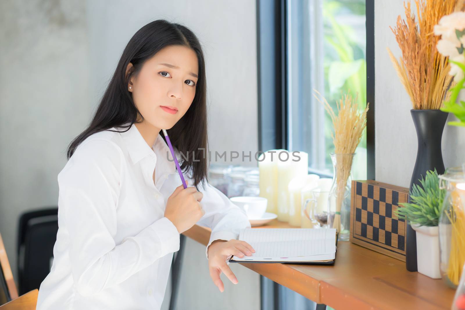 Beautiful asian young woman working online with laptop and think project for idea at modern cafe shop, business and freelance concept.