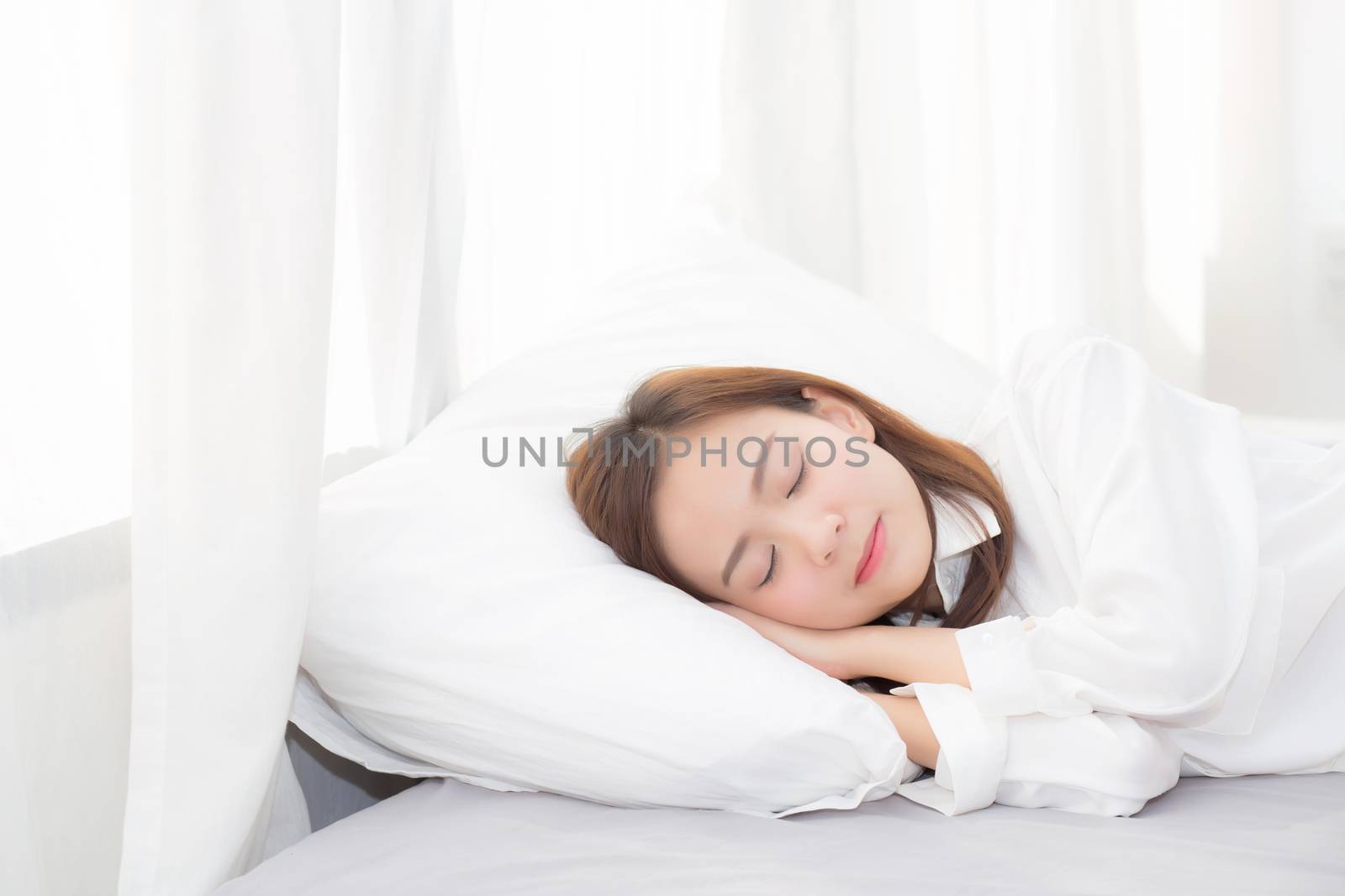 Beautiful asian young woman sleeping lying in bed on bedroom with head on pillow comfortable and happy, girl with relax for health welness and lifestyle concept.