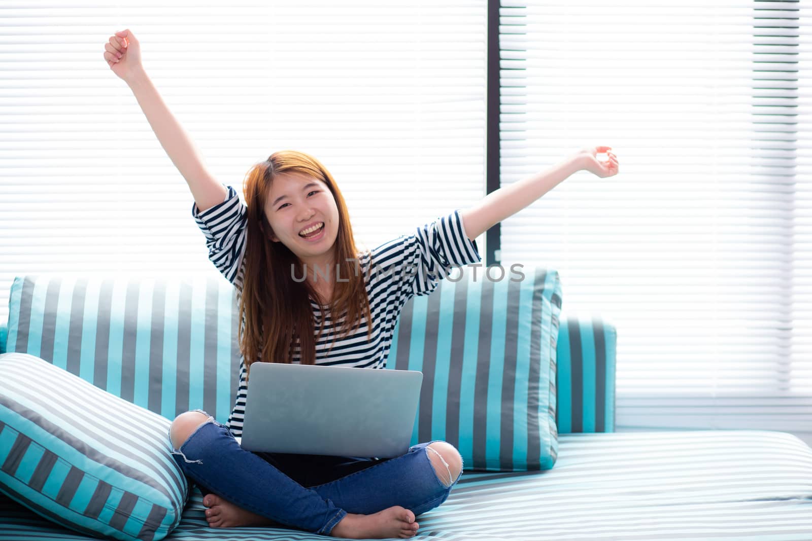 Beautiful happiness portrait of young asian woman using laptop work with success on sofa in the home, girl and notebook internet online with glad, communication concept.