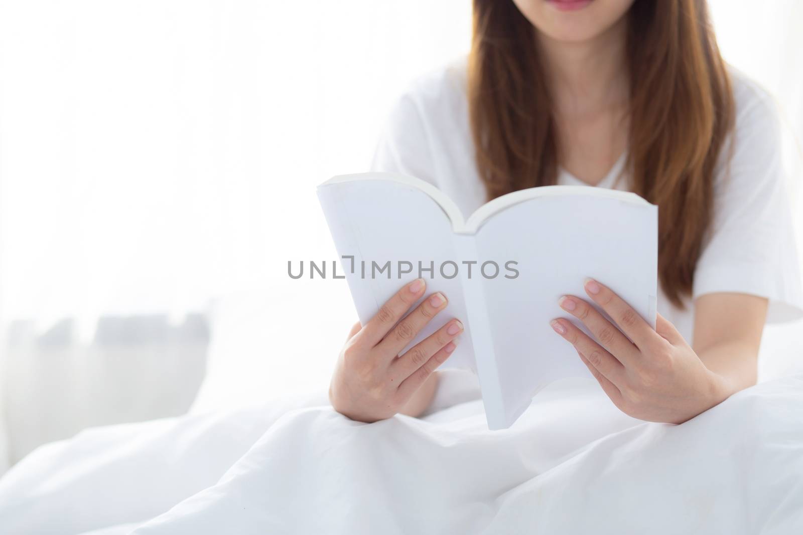Beautiful of portrait young asian woman relax sitting reading book on bedroom at home, girl study literature, education and llifestyle concept.