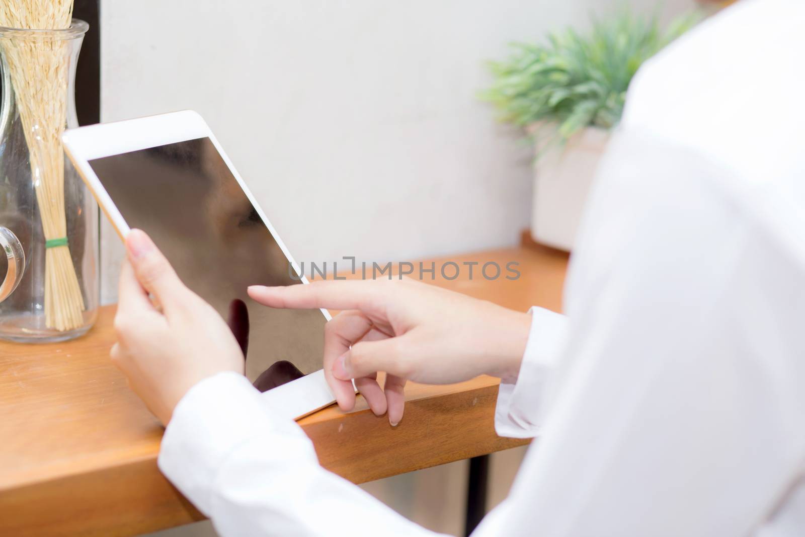 Closeup beautiful asian businesswoman holding tablet, woman hand touch screen using digital tablet computer and working internet online coffee shop, communication concept.