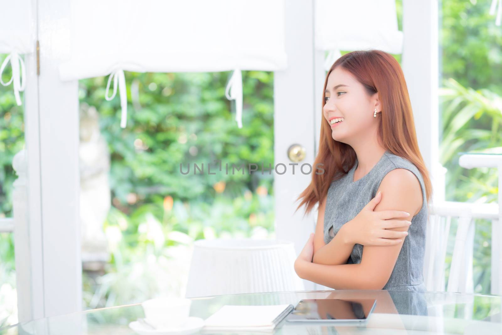 Beautiful of portrait businesswoman have enjoy in the garden with tablet and book, woman relax sitting in the park with smile and happy, communication and lifestyle concept.