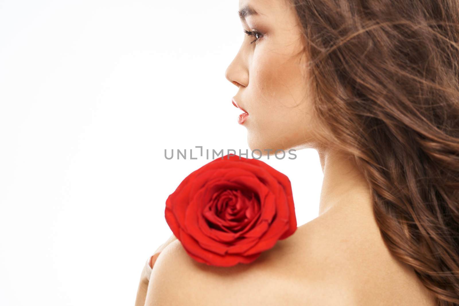 Woman with naked shoulders and red rose evening makeup light background. High quality photo