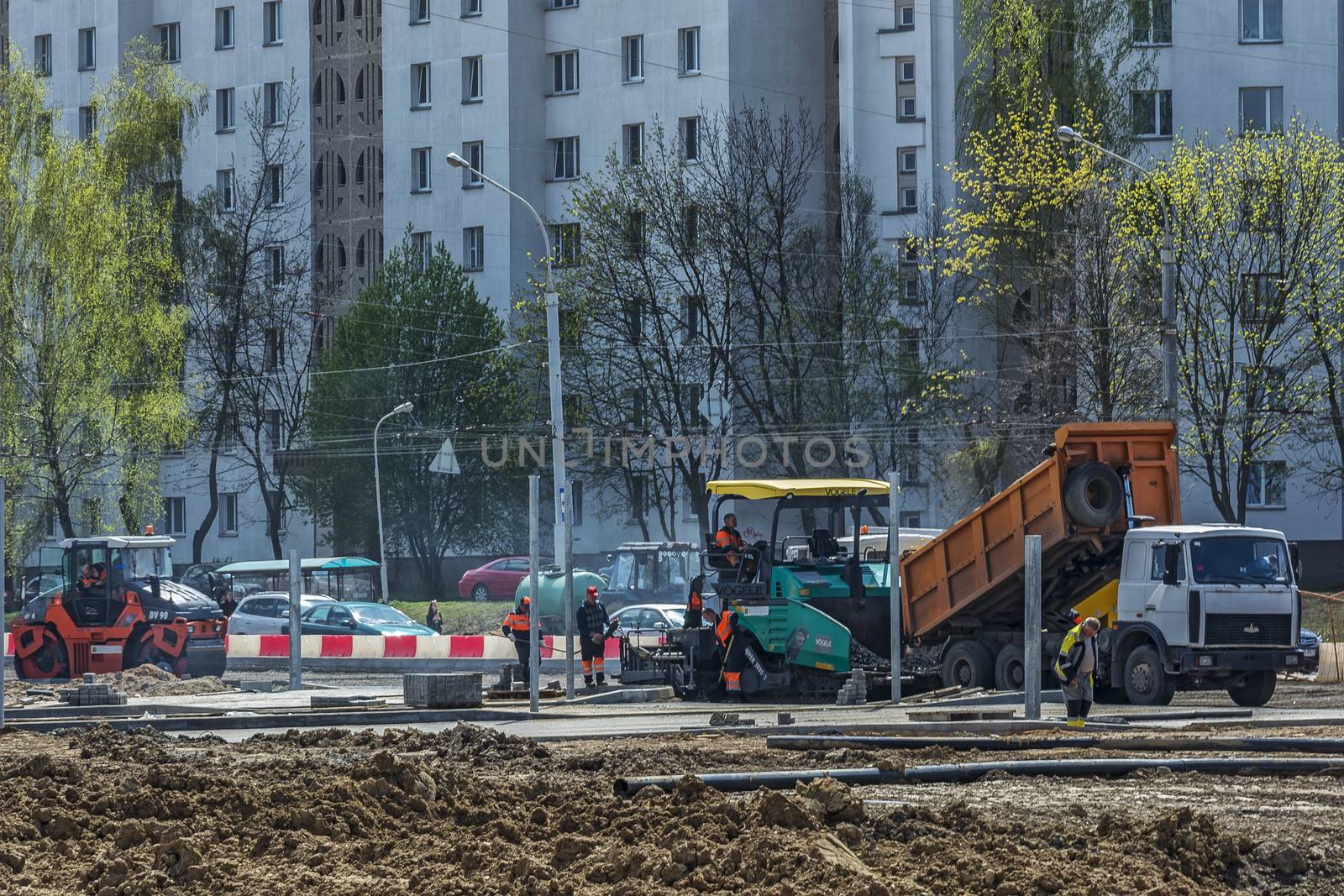 Belarus, Minsk - 06.05.2017: Dump truck, unloads asphalt into special equipment for paving asphalt
