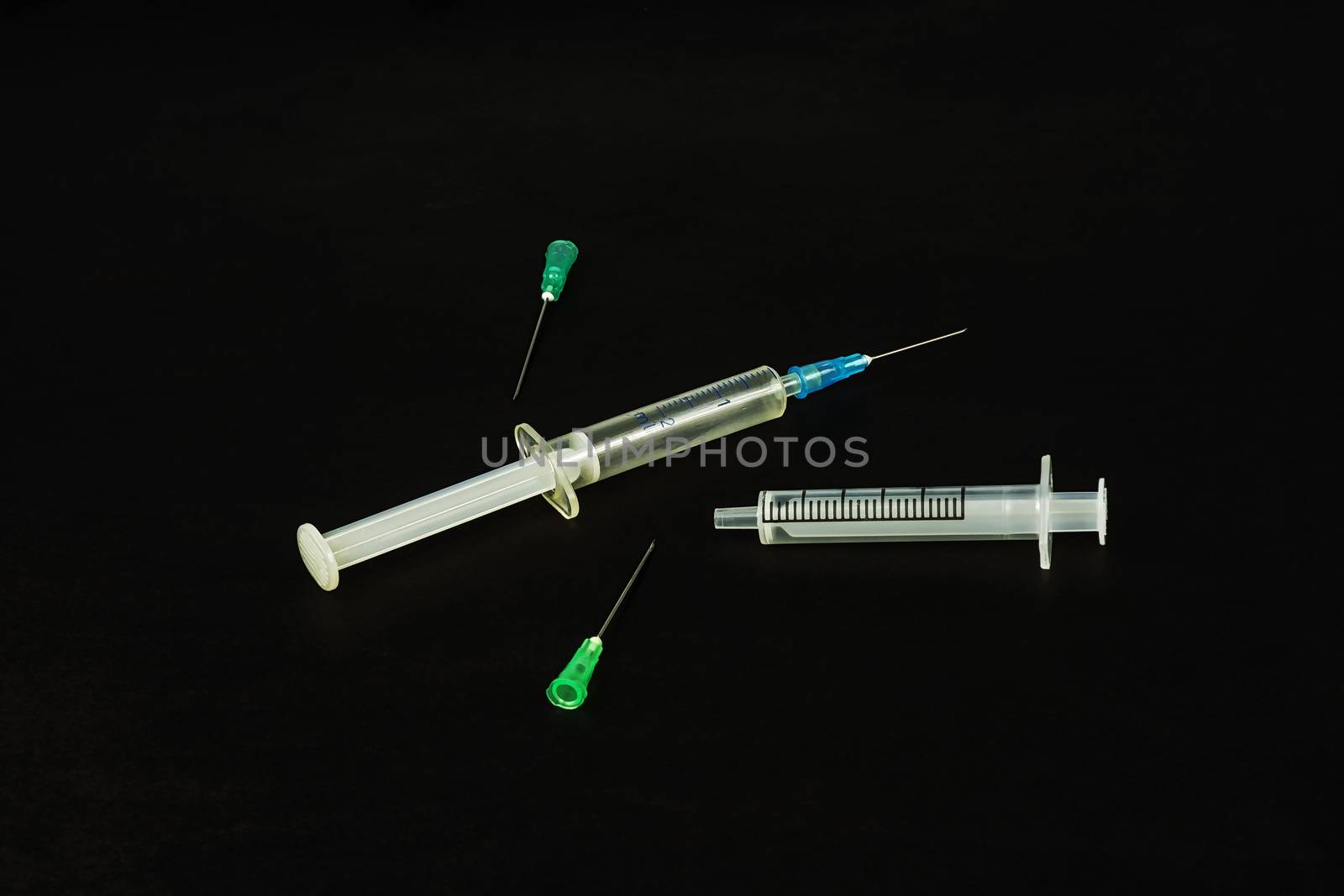 On a black background, there are syringes and needles by Grommik