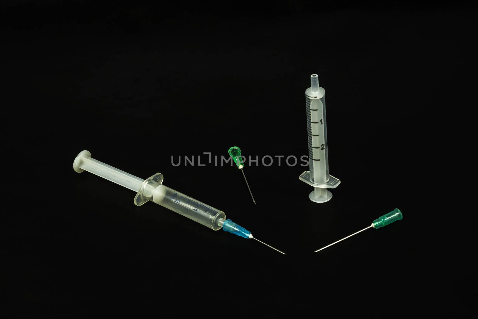 Medical syringe and needles on a black background