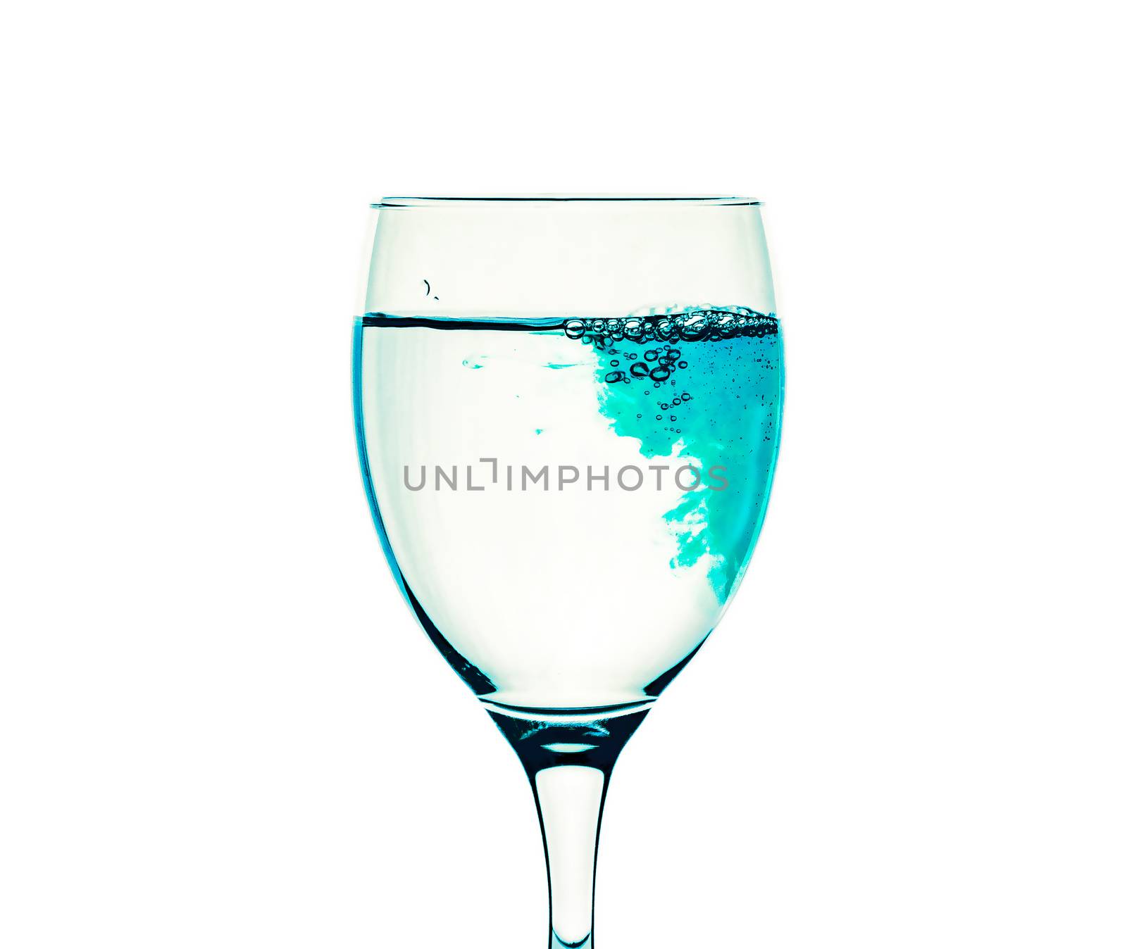 A glass with clear water is filled with blue liquid by Grommik