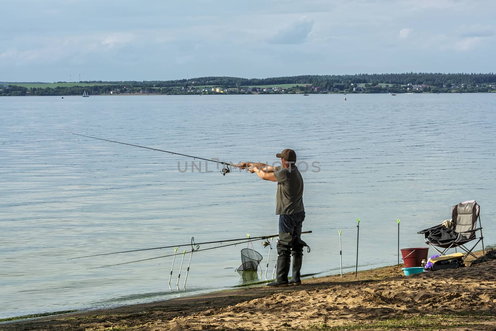 On the shore of the lake, a man installed fishing rods for fishing